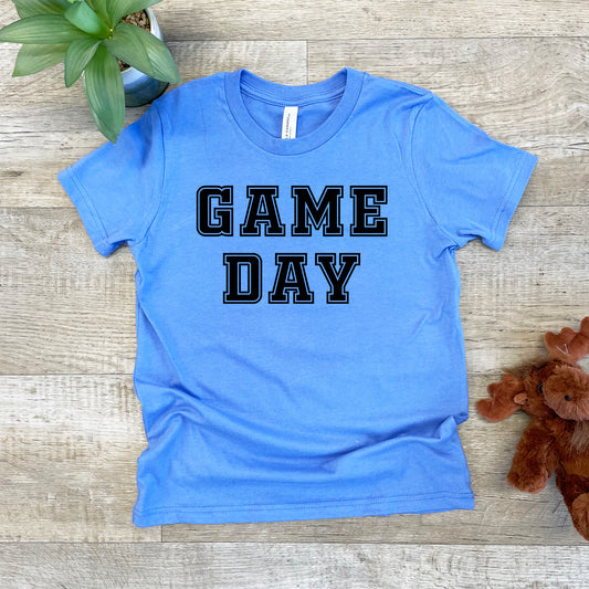 a blue shirt that says game day next to a teddy bear