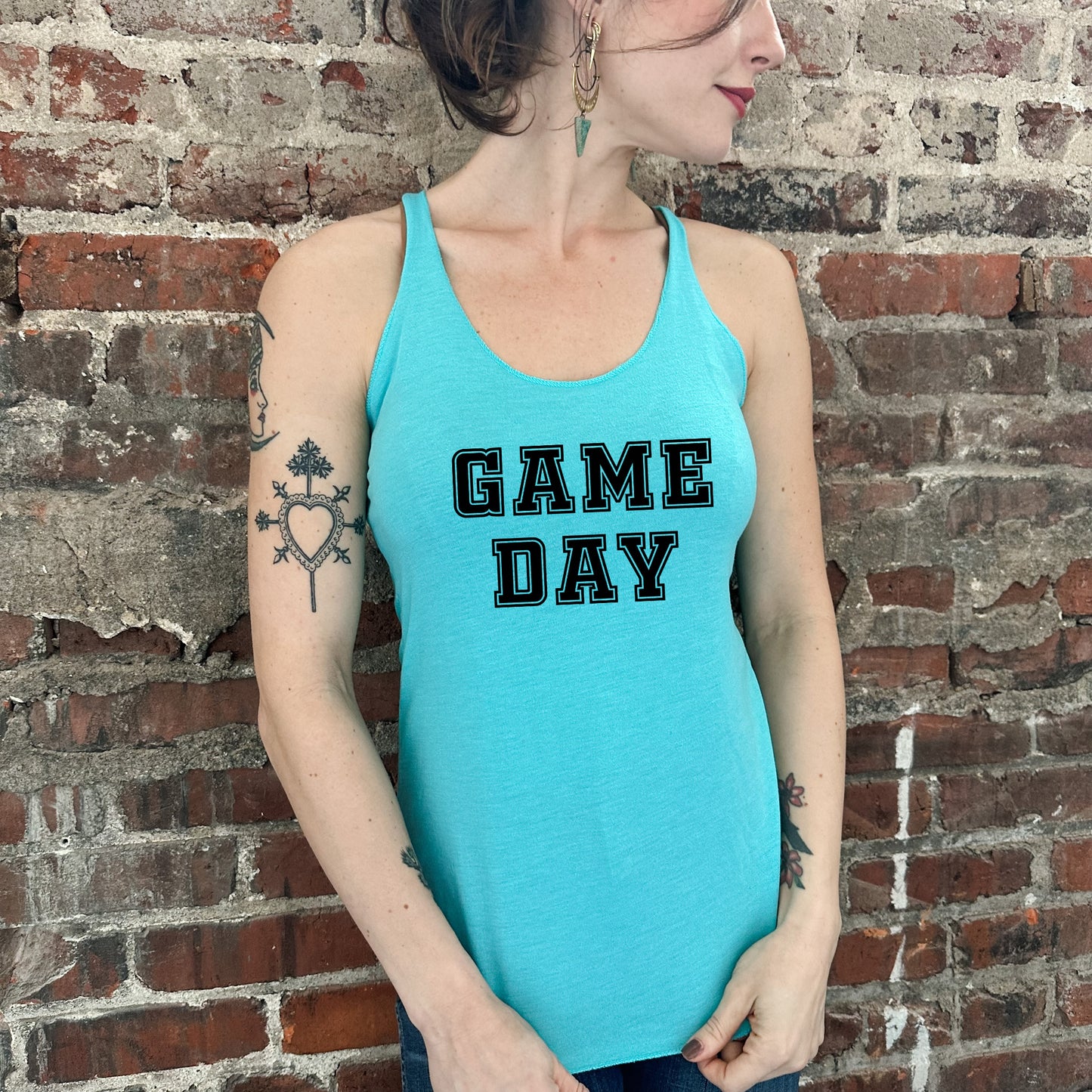 a woman wearing a blue tank top that says game day