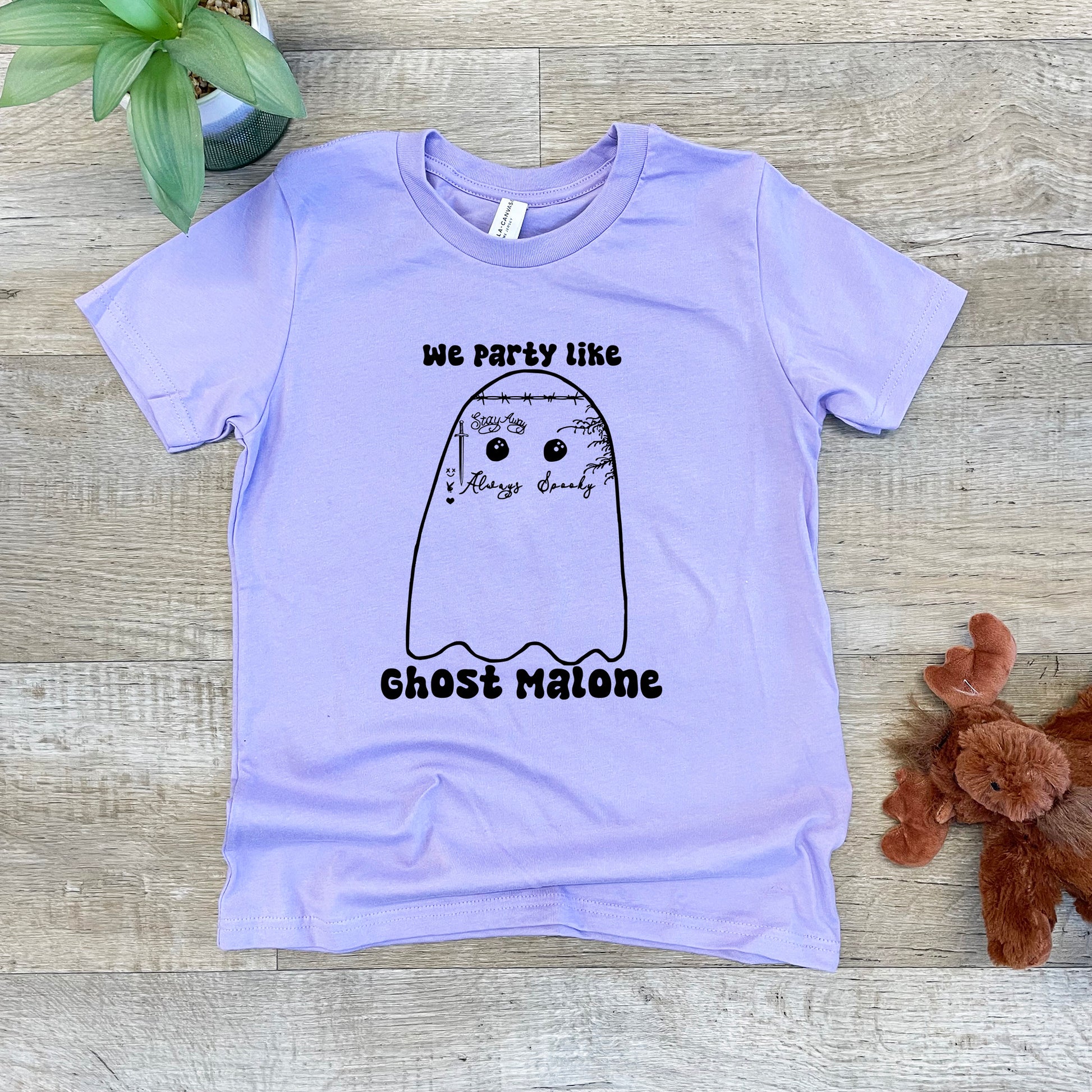 a purple t - shirt with a slotty like ghost on it