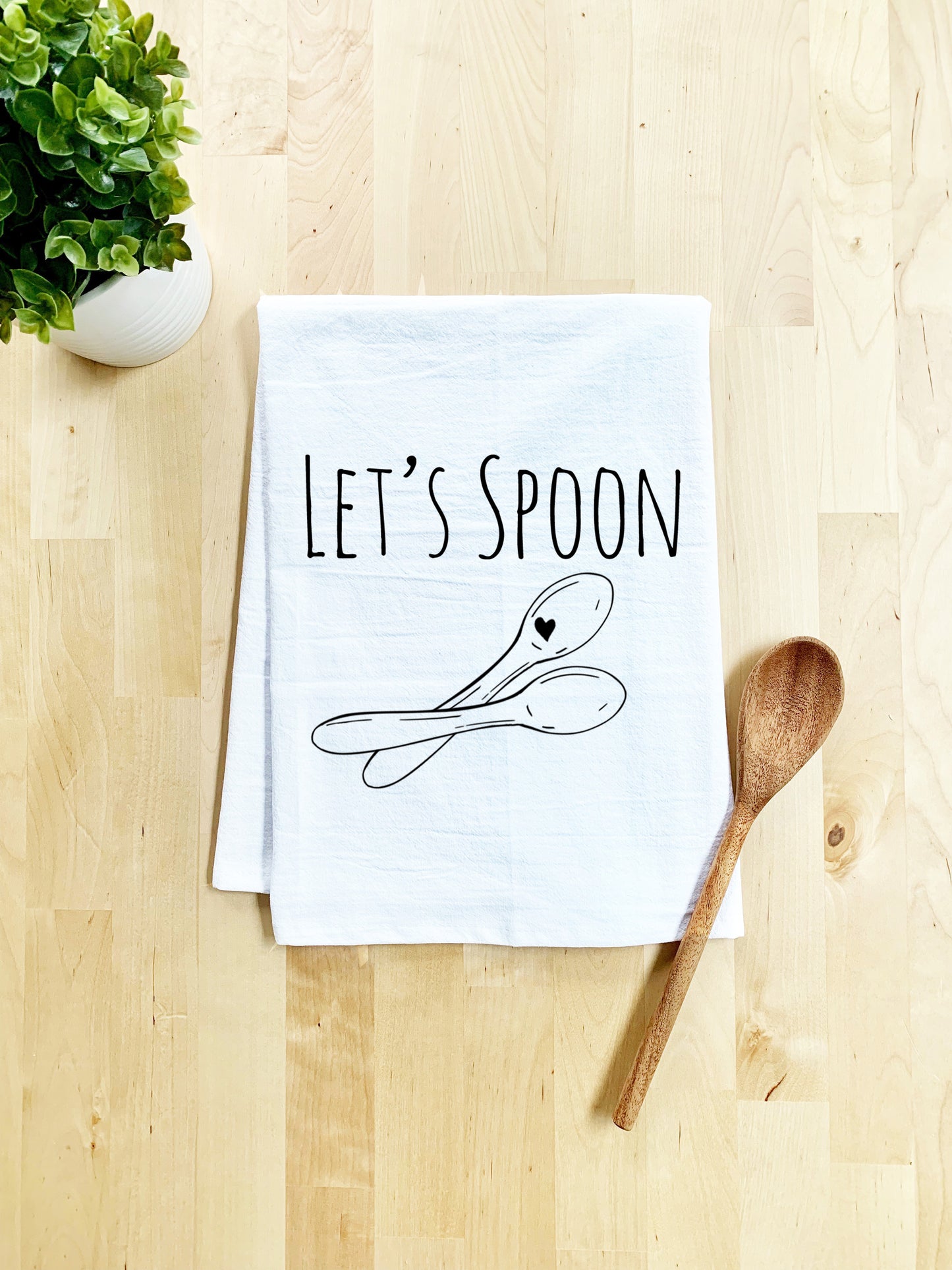 a kitchen towel that says let's spoon on it next to a wooden spoon