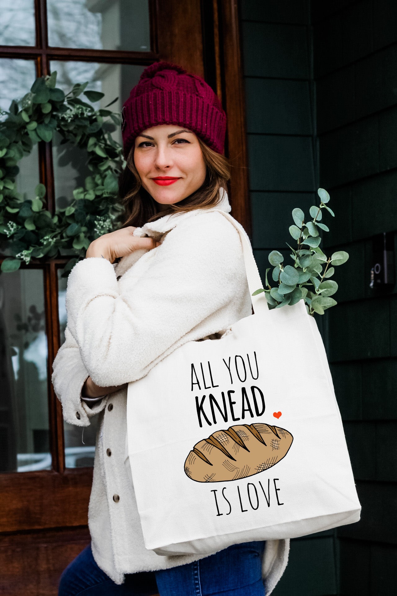 a woman carrying a bag that says, all you knead is love
