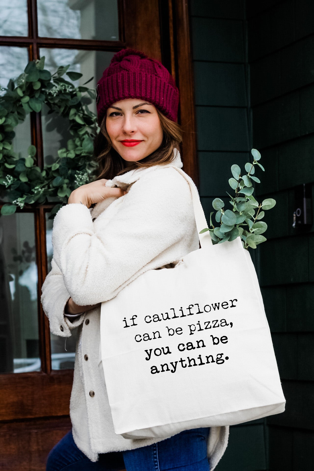 a woman holding a white bag with a quote on it
