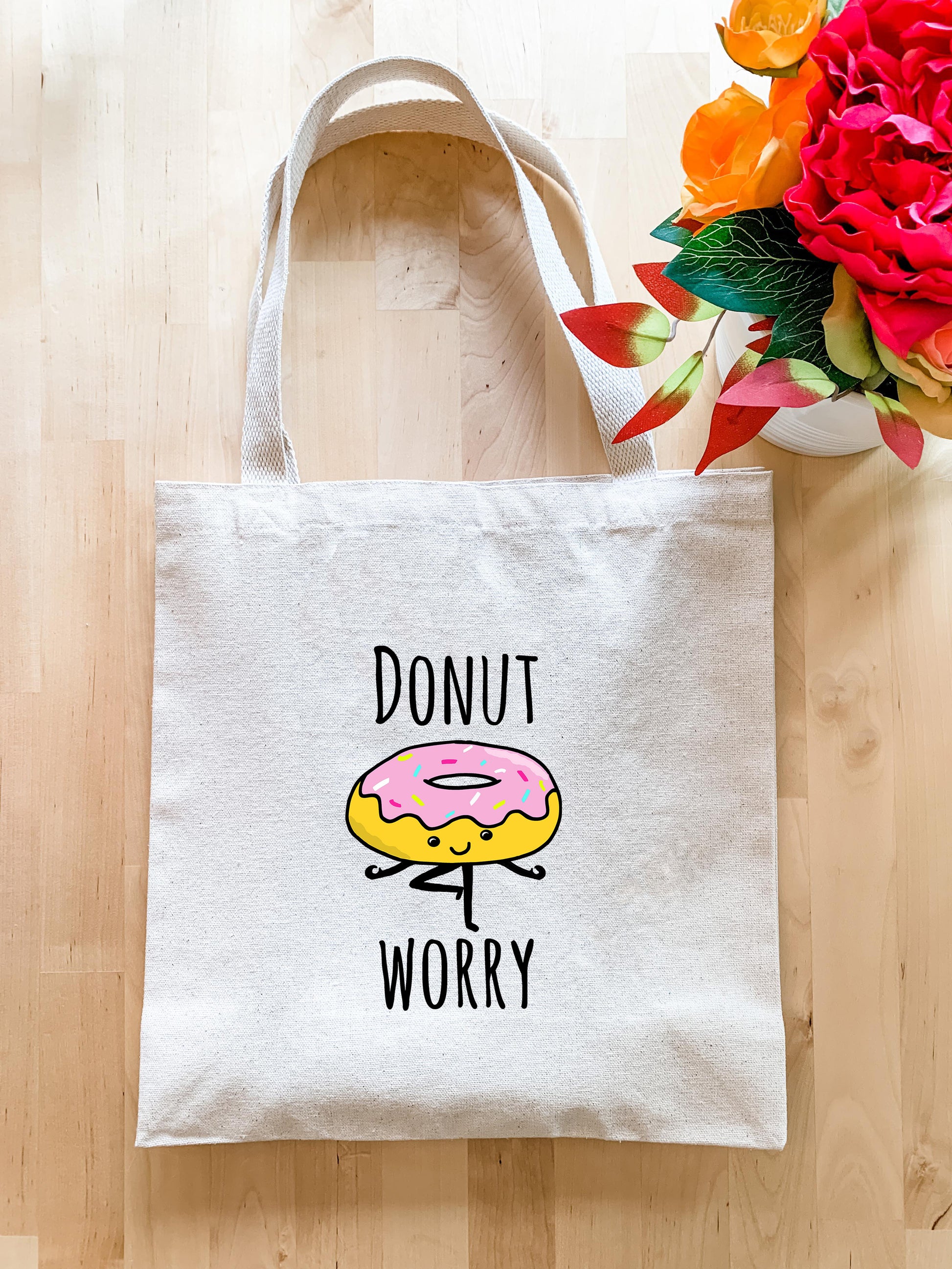 a donut worry bag next to a vase of flowers