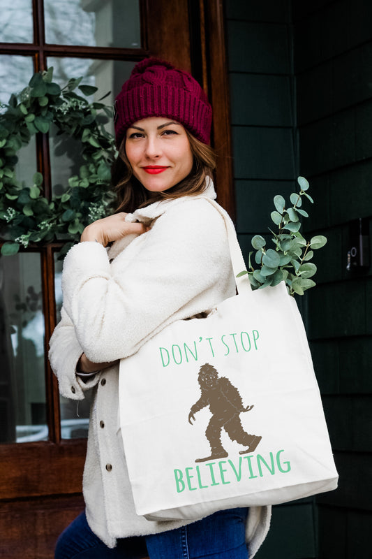 a woman carrying a bag that says don't stop believing