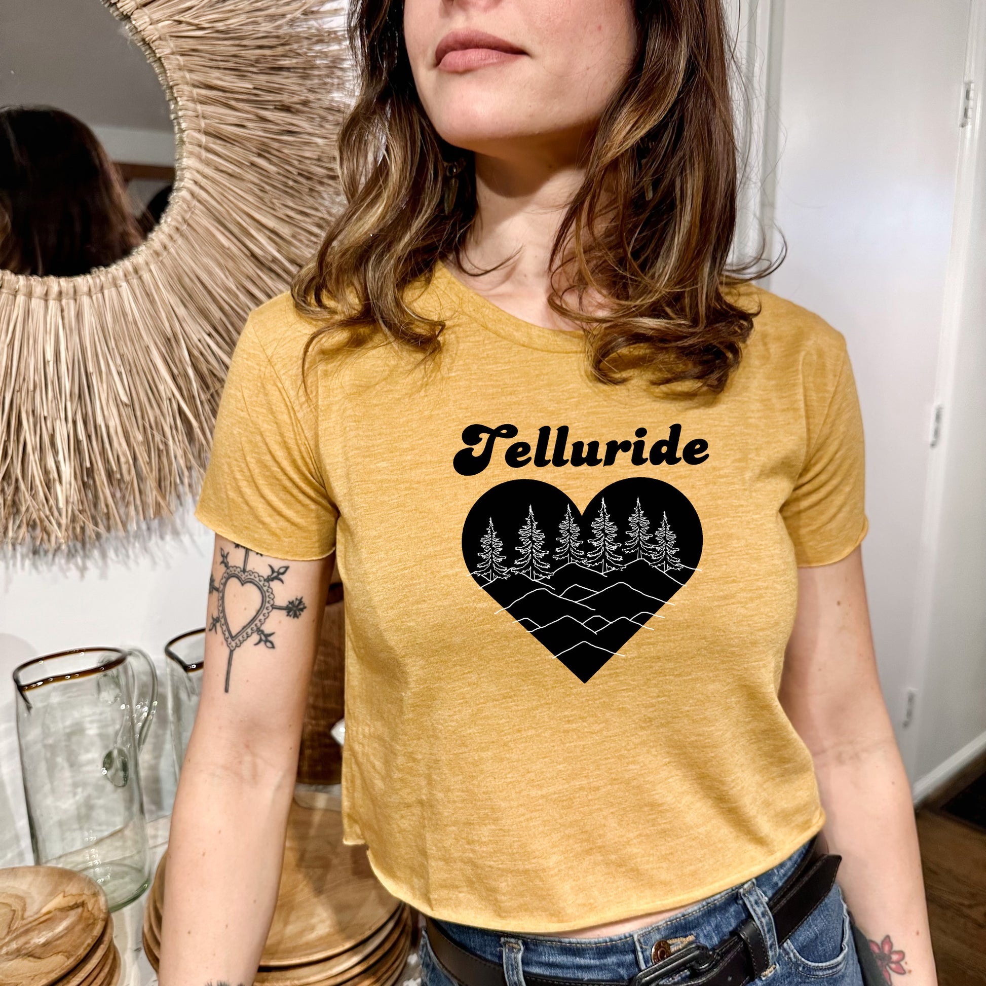 a woman standing in front of a mirror wearing a yellow t - shirt