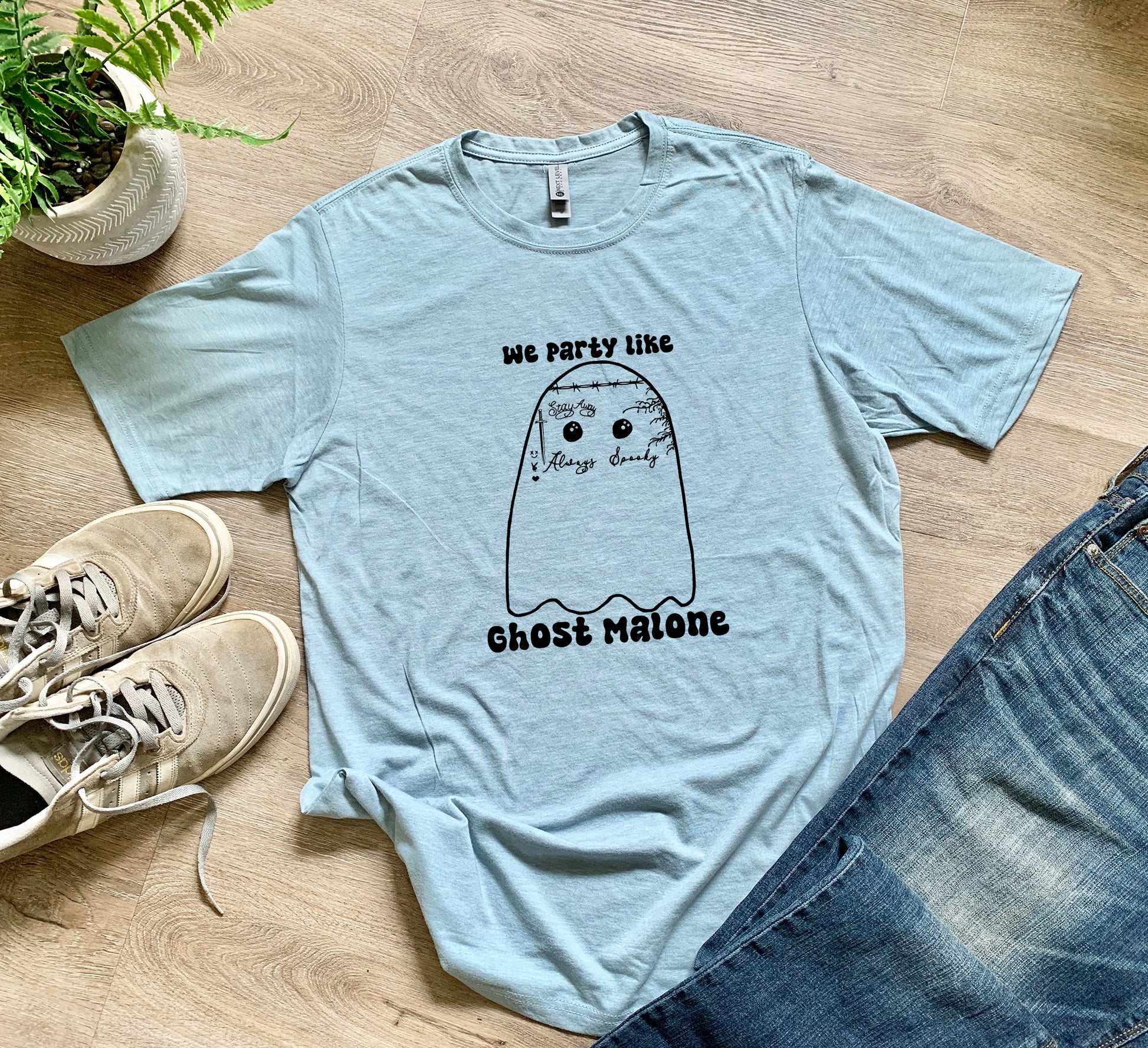 a t - shirt with a ghost on it next to a pair of jeans