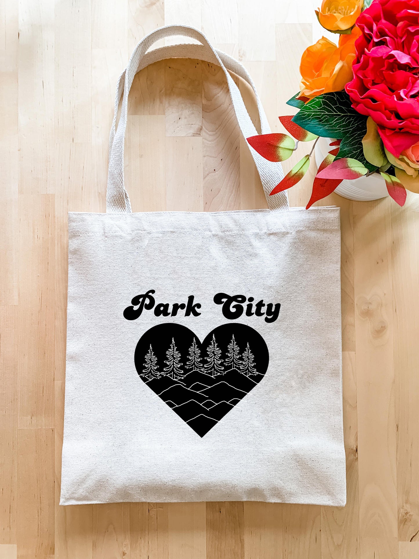 a white tote bag with a black heart and trees on it
