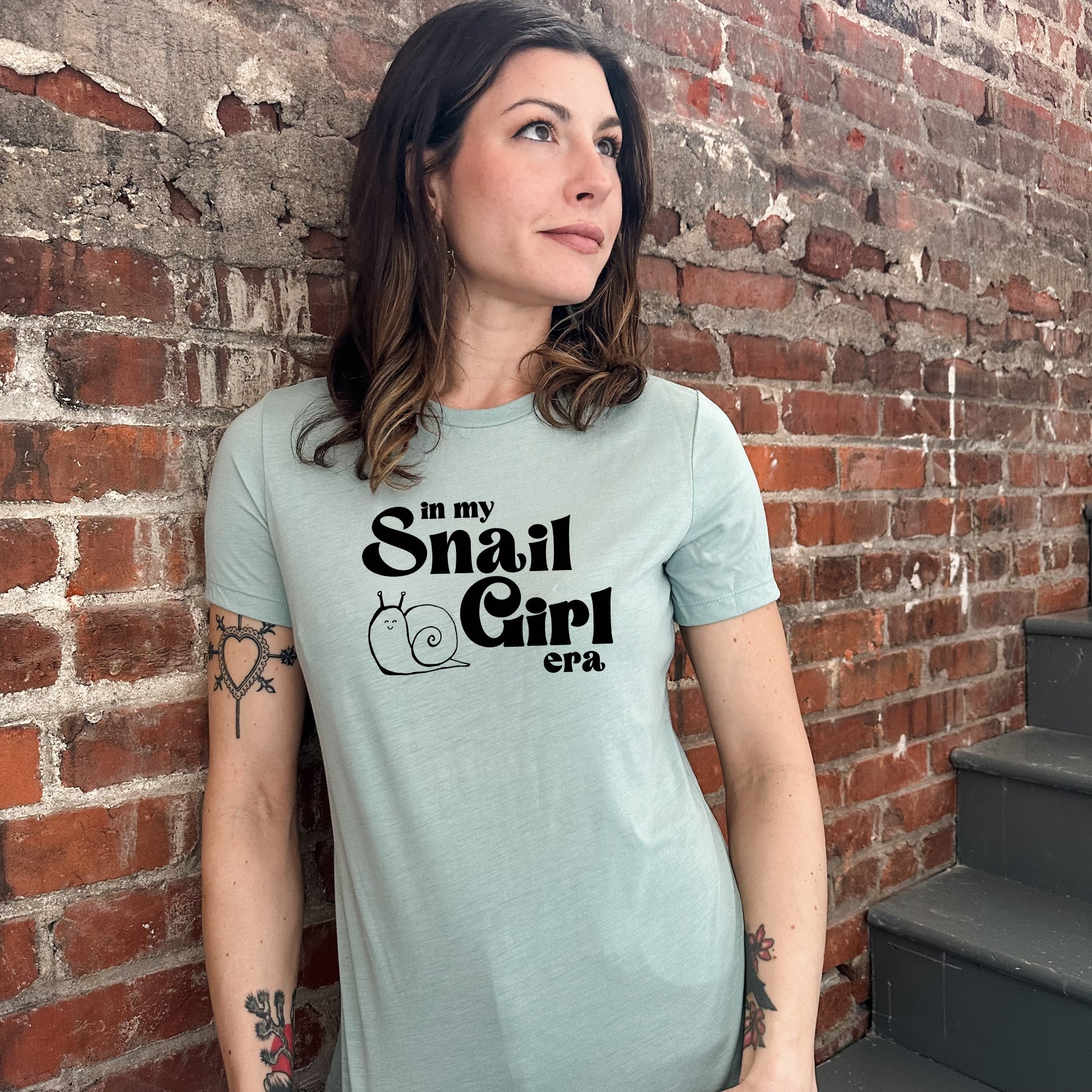 a woman standing in front of a brick wall