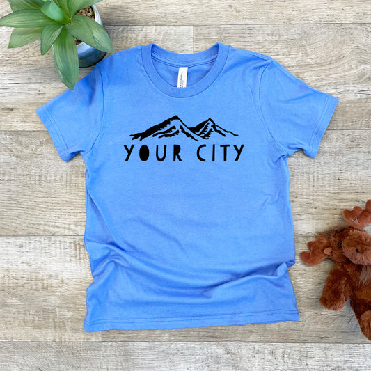 a t - shirt that says your city on it next to a teddy bear