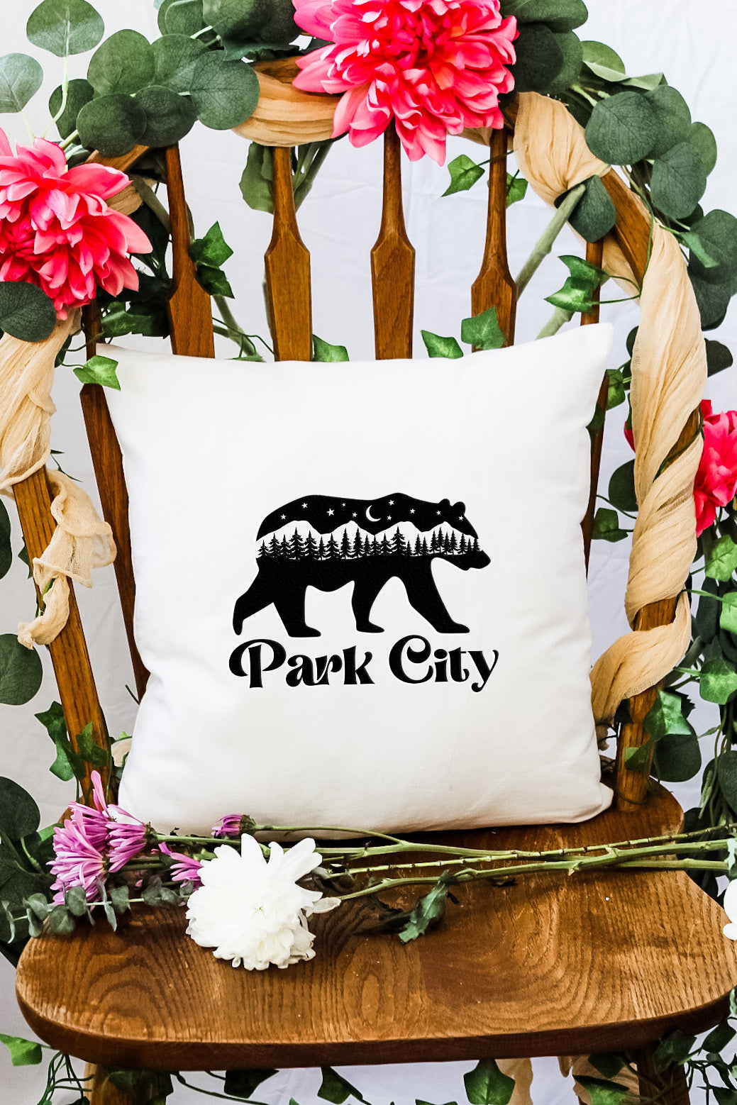 a bear pillow sitting on top of a wooden chair