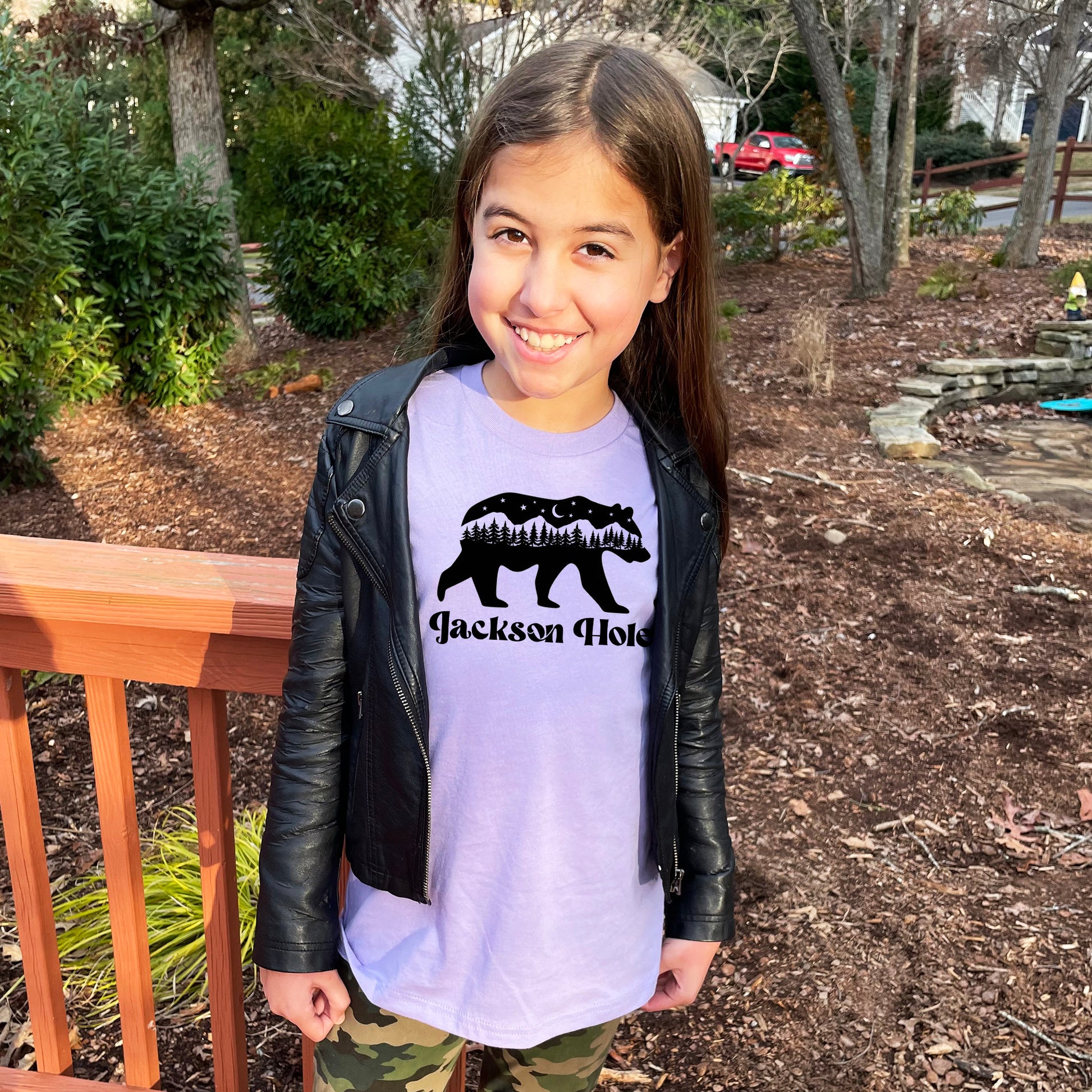 a young girl wearing a t - shirt with a bear on it