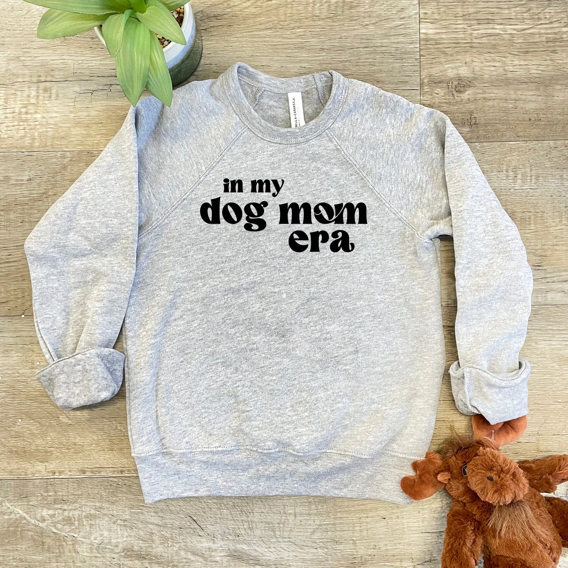 a gray sweatshirt with the words in my dog mom era on it next to a
