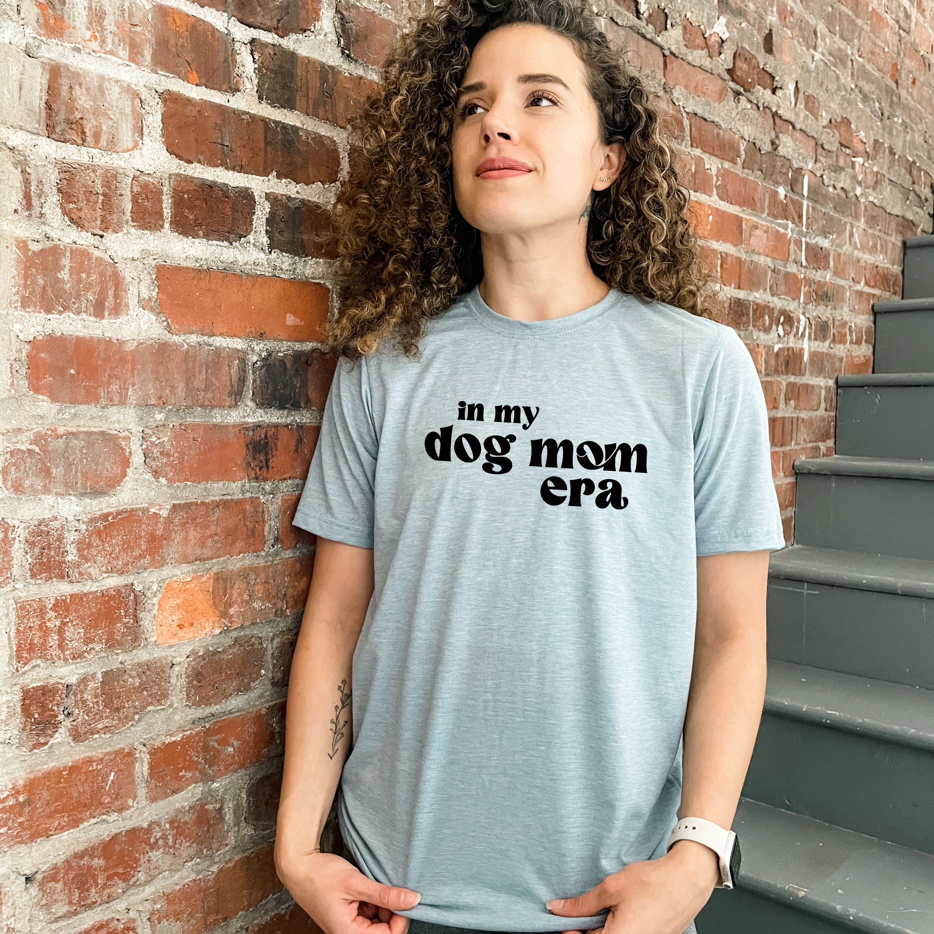 a woman standing in front of a brick wall