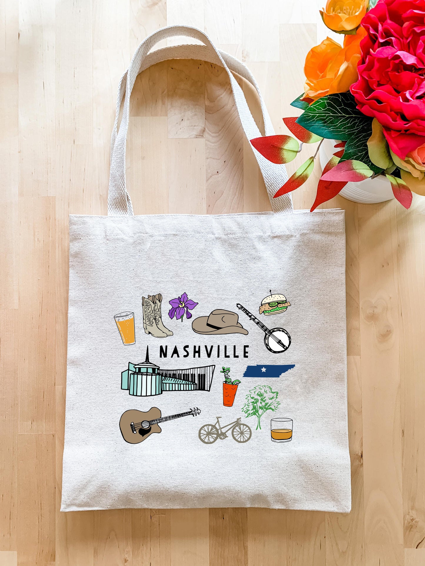 a tote bag sitting on a table next to a vase of flowers