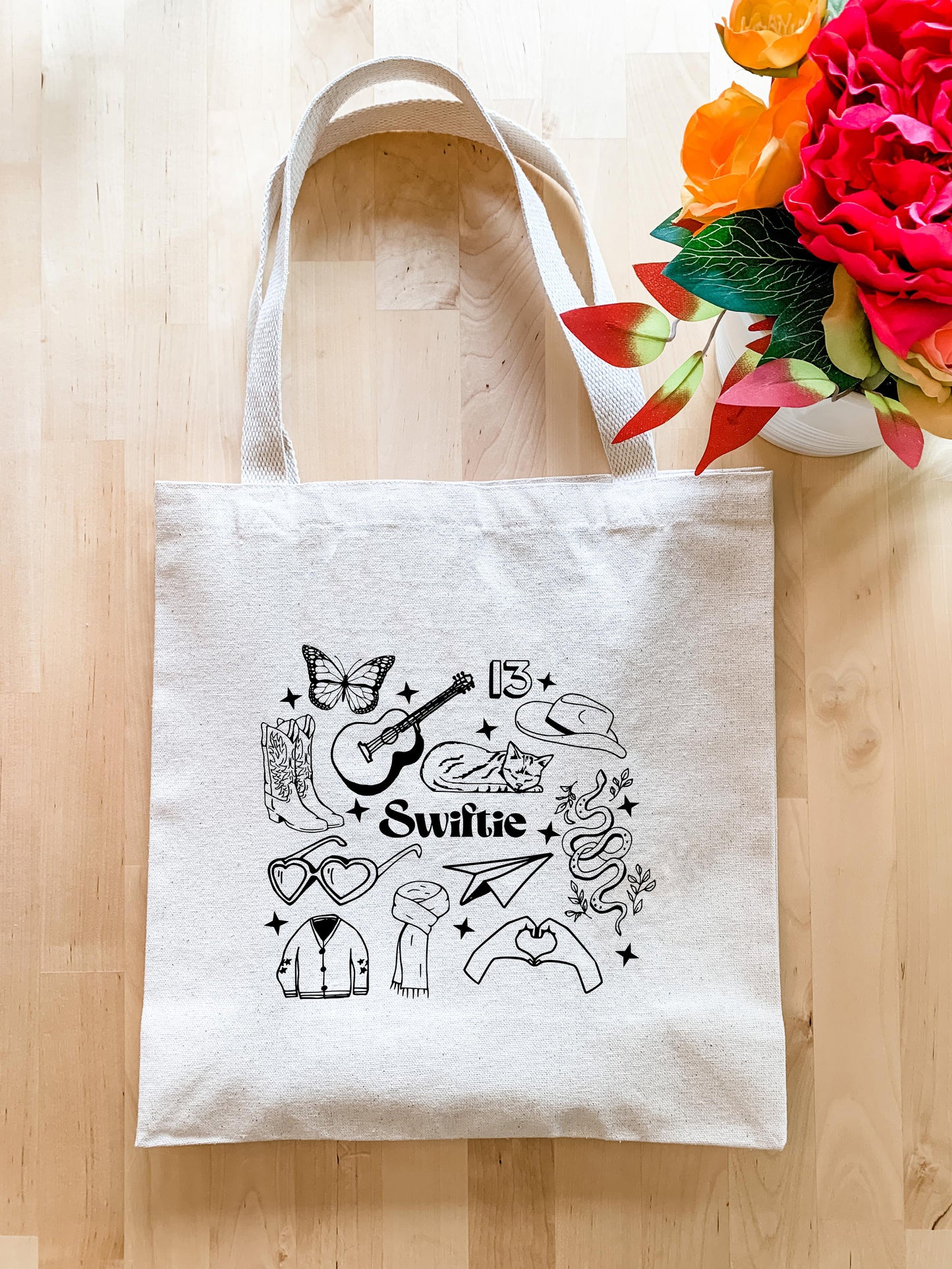 a white tote bag sitting on top of a wooden floor