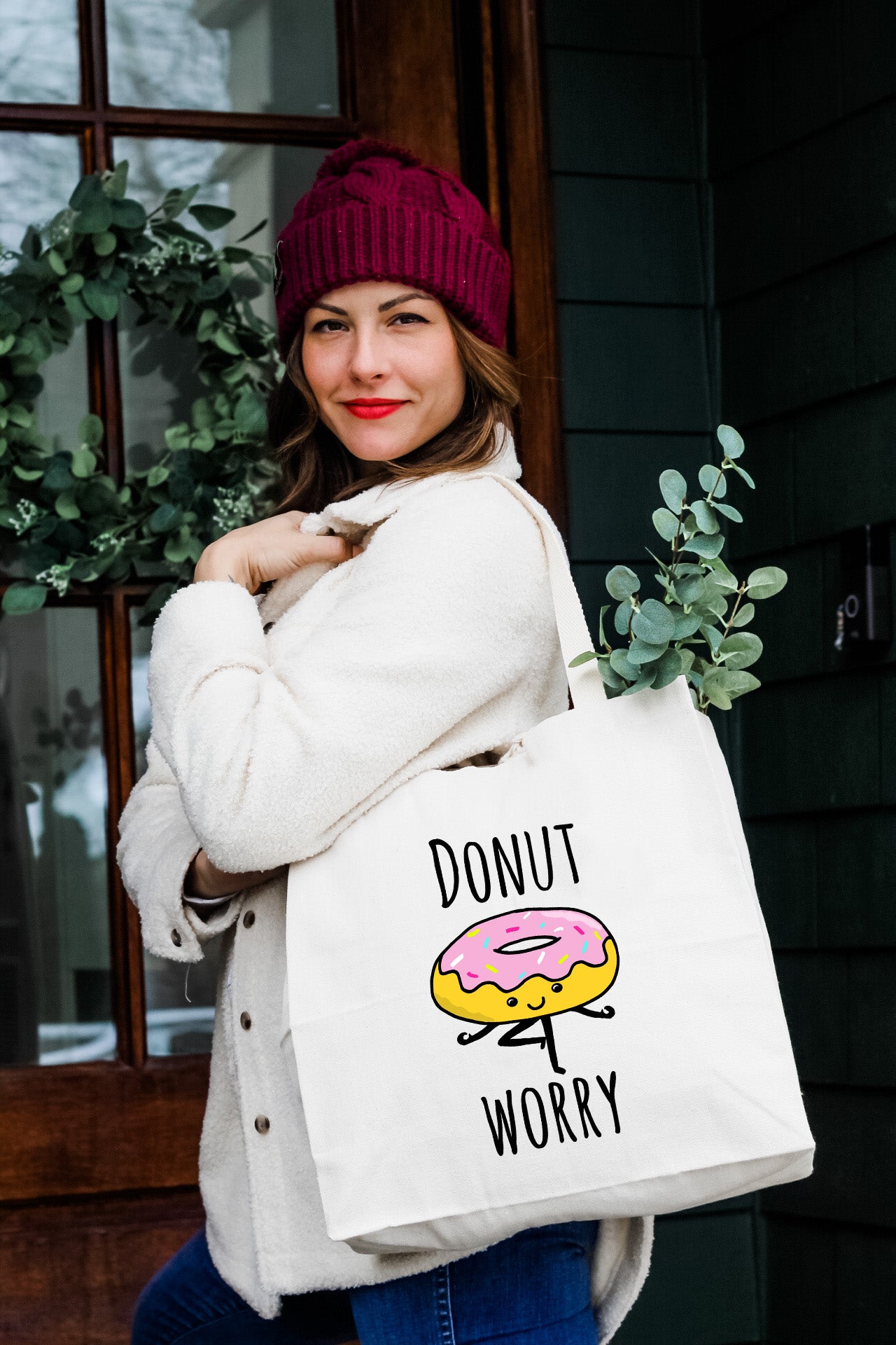 a woman is holding a donut worry bag