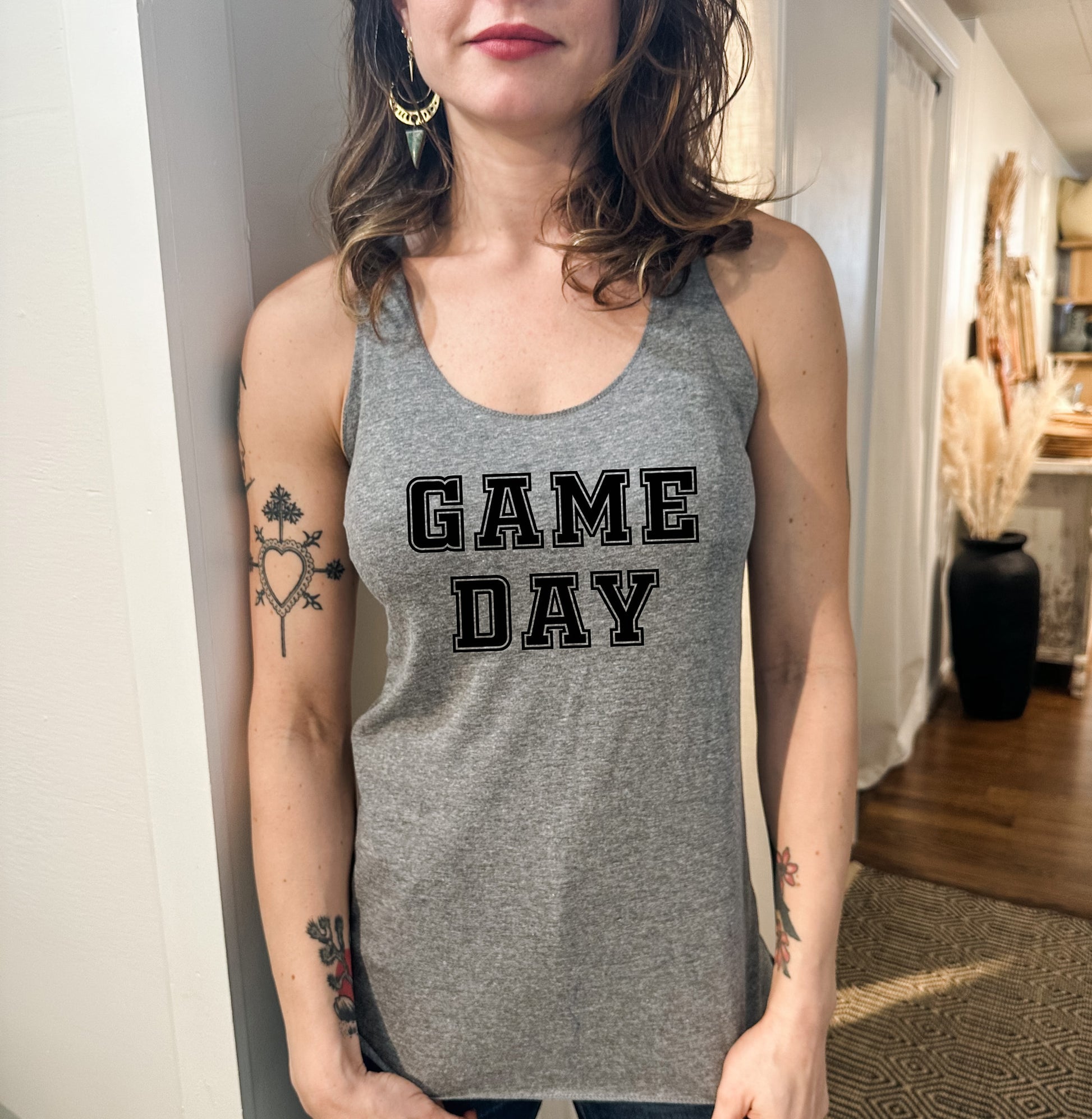 a woman wearing a gray tank top with game day on it