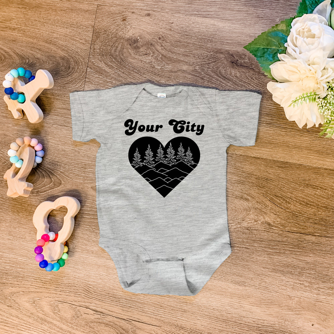 a baby bodysuit with a heart and trees on it