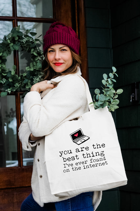 a woman holding a white bag with a quote on it