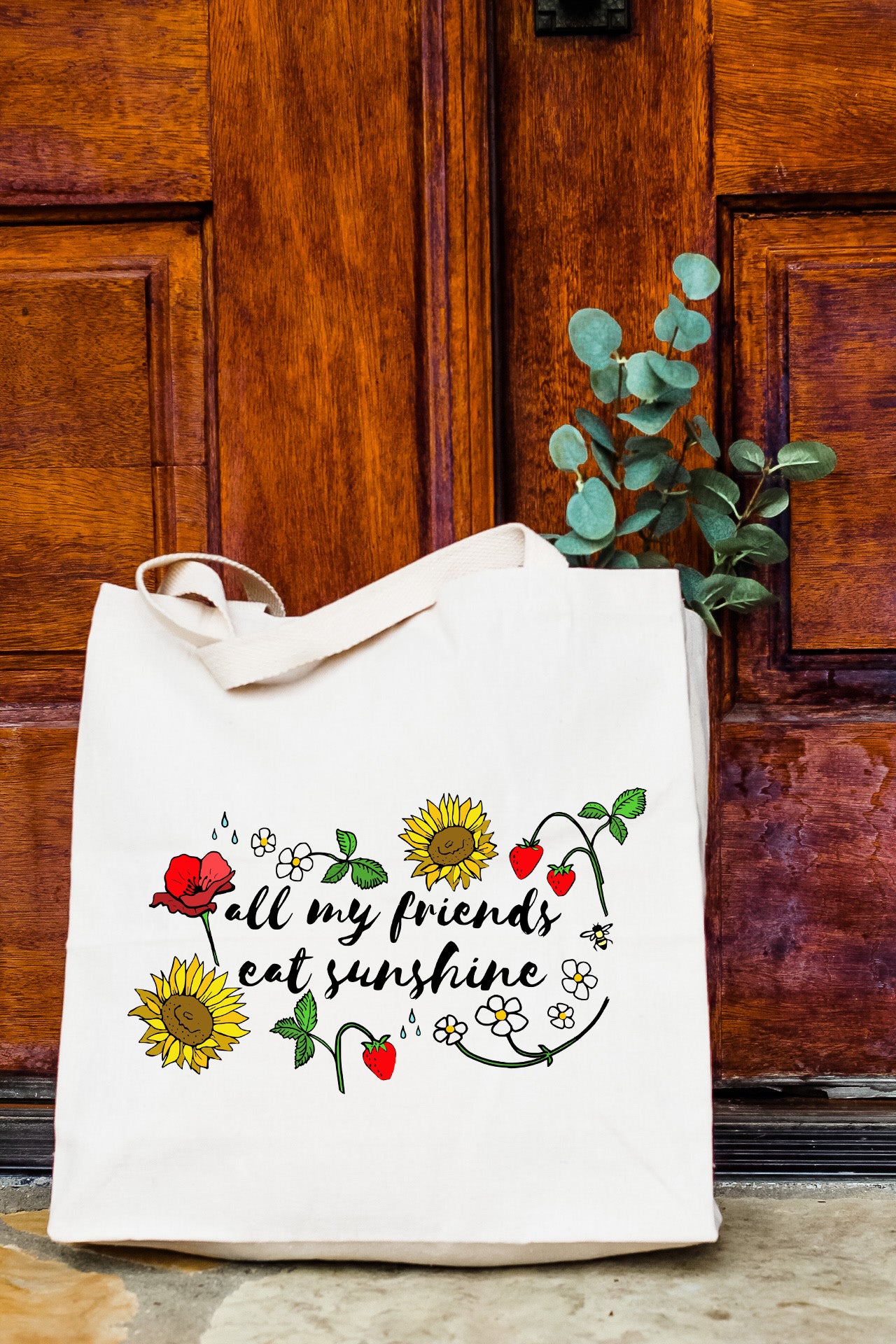 a white tote bag sitting on top of a wooden door