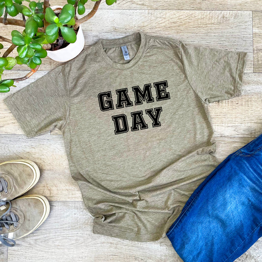 a t - shirt that says game day next to a potted plant