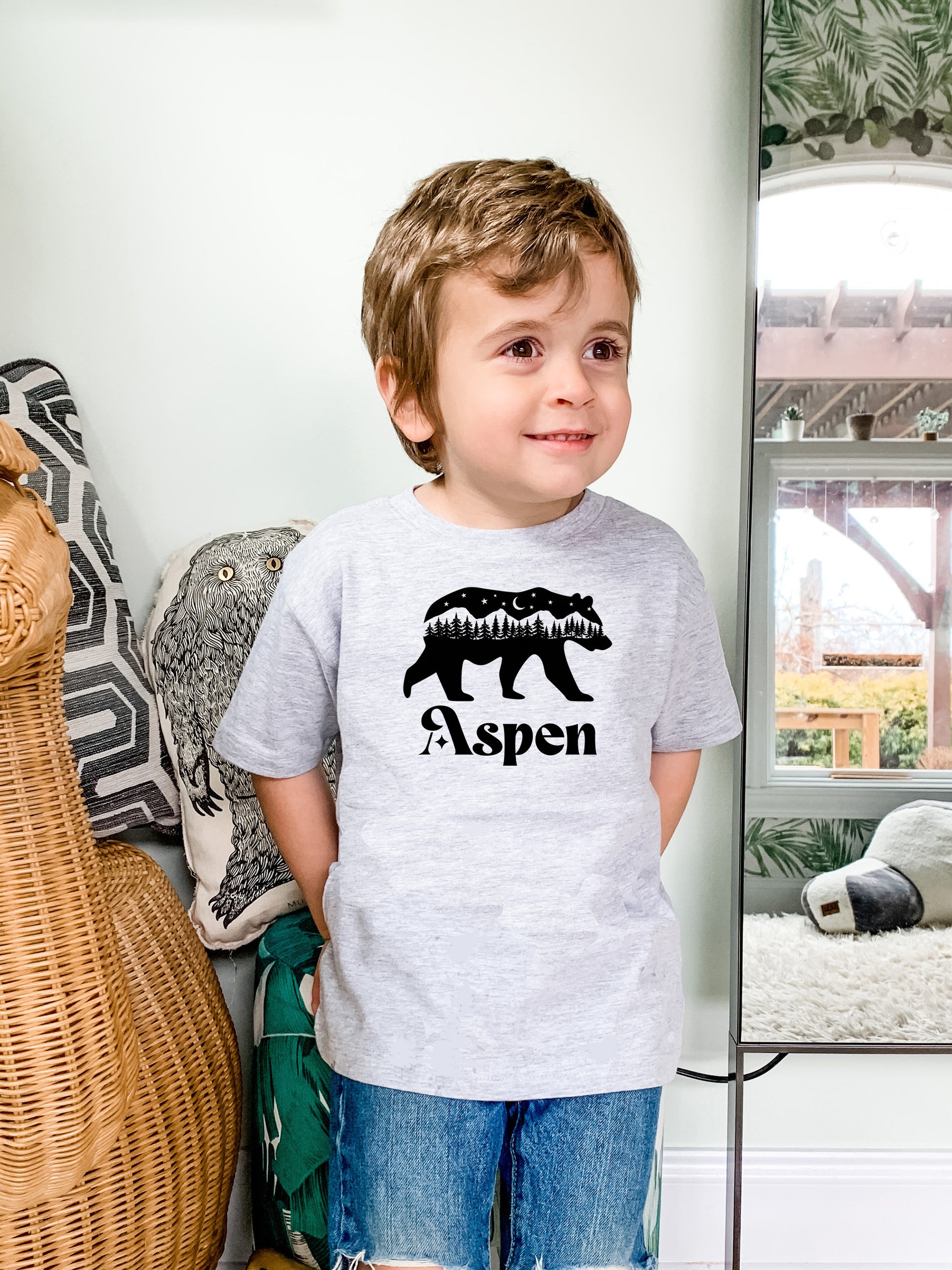 a young boy standing in front of a mirror