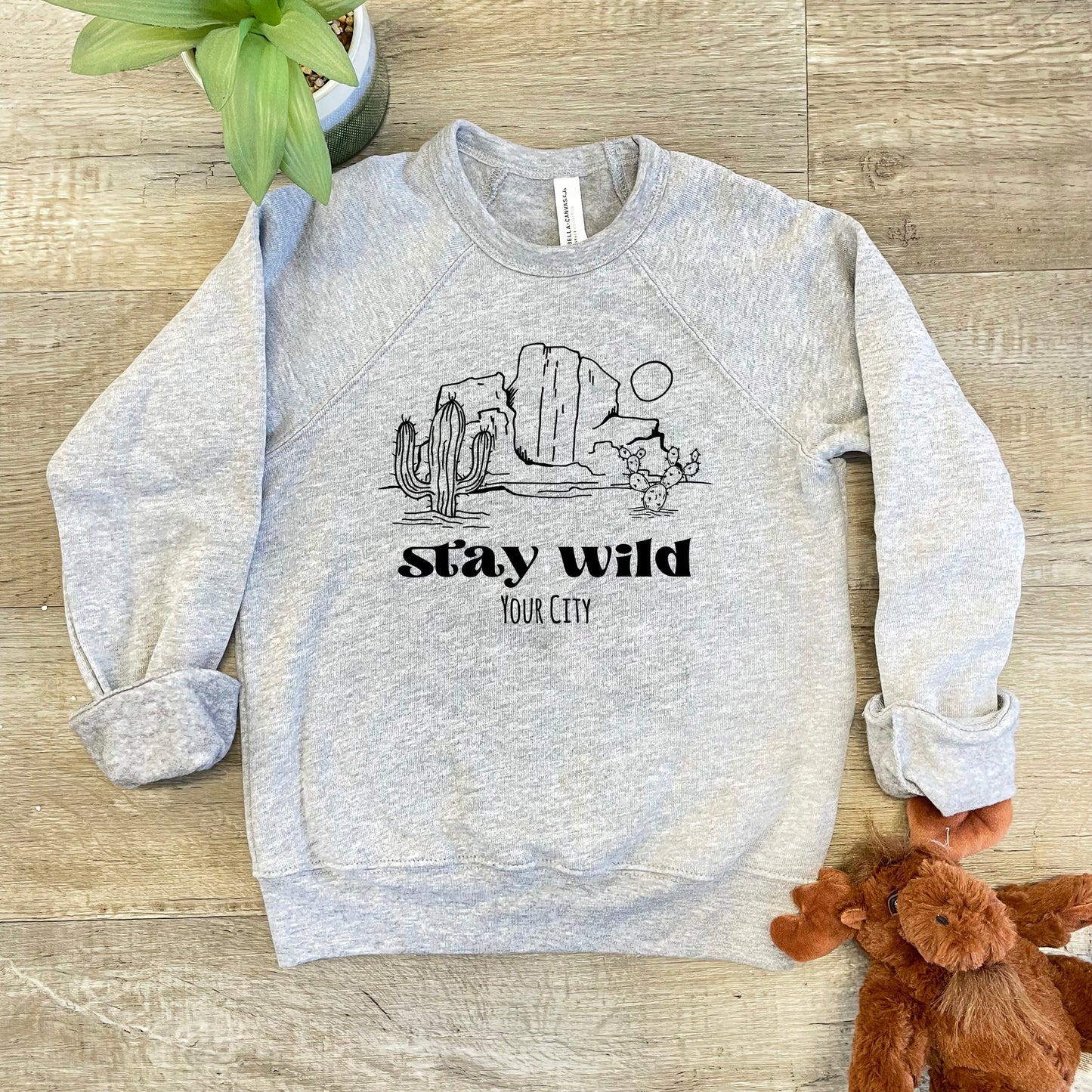 a gray sweatshirt with a cactus and a teddy bear