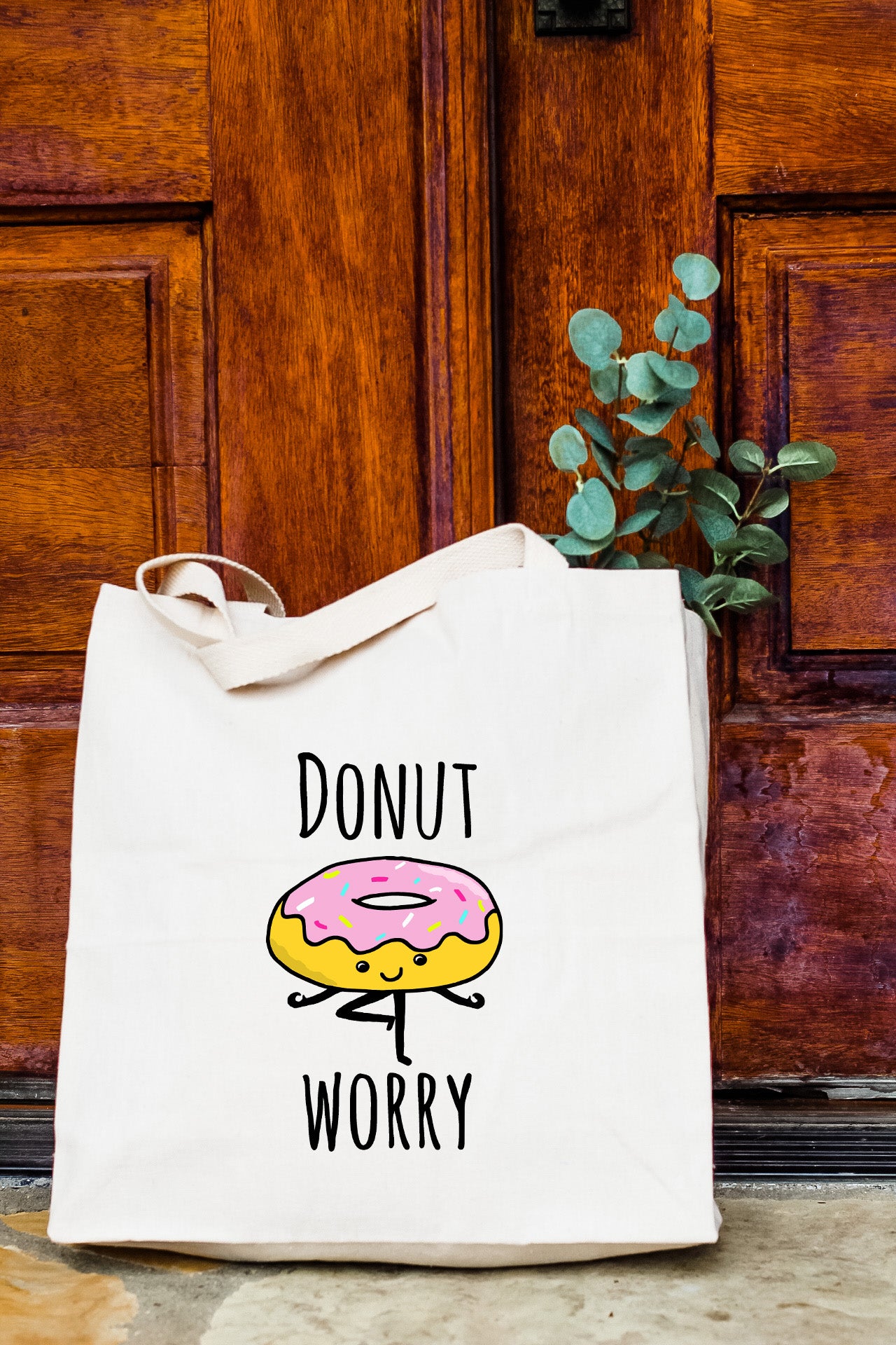 a white bag with a donut on it sitting in front of a door