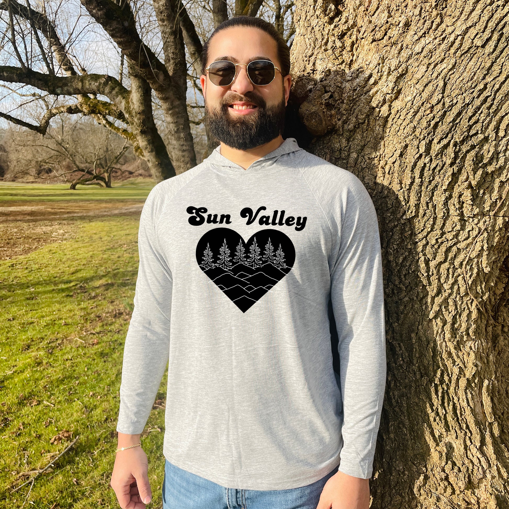 a man standing next to a tree with a heart on it