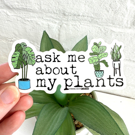 a hand holding a sticker that says ask me about my plants