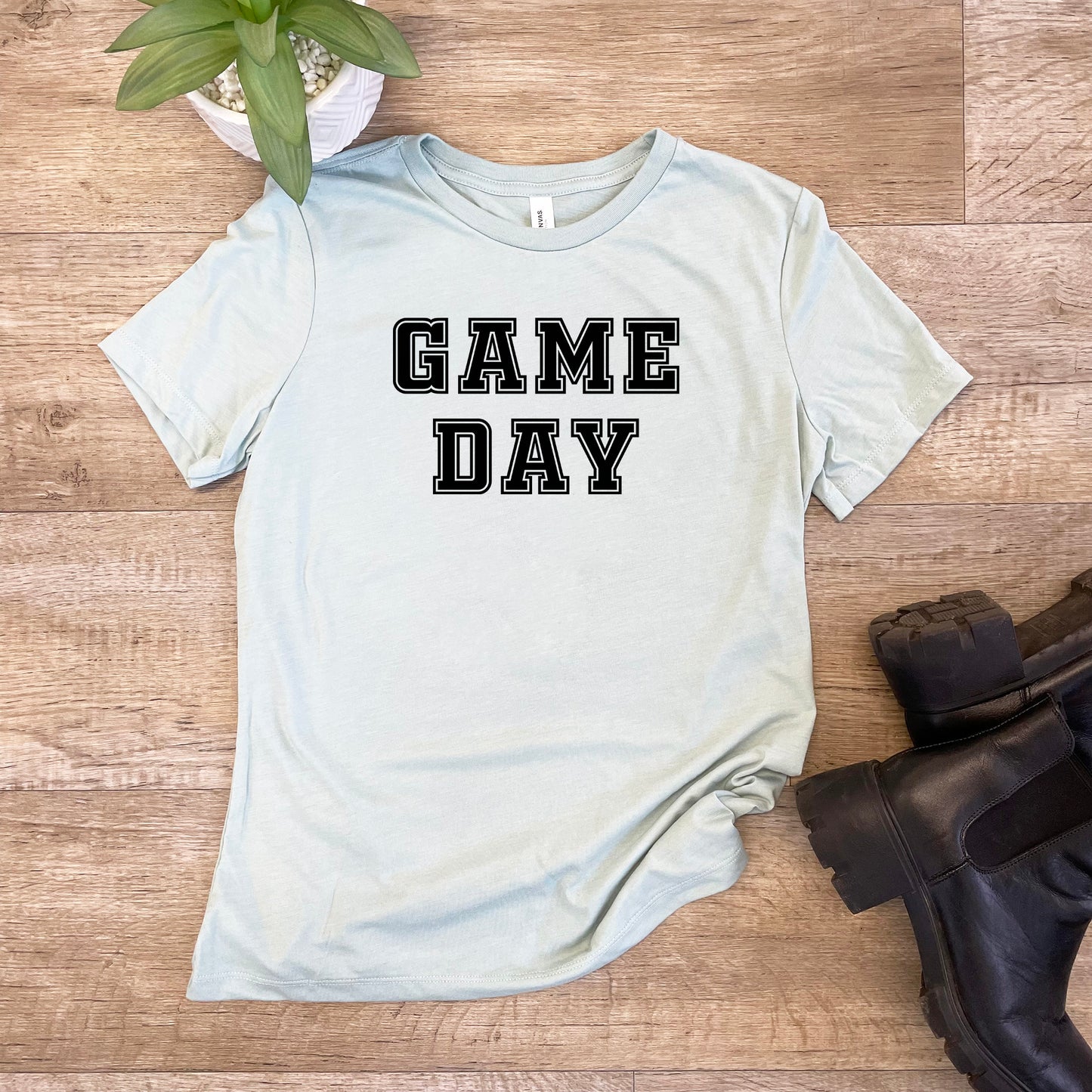 a t - shirt that says game day next to a pair of boots