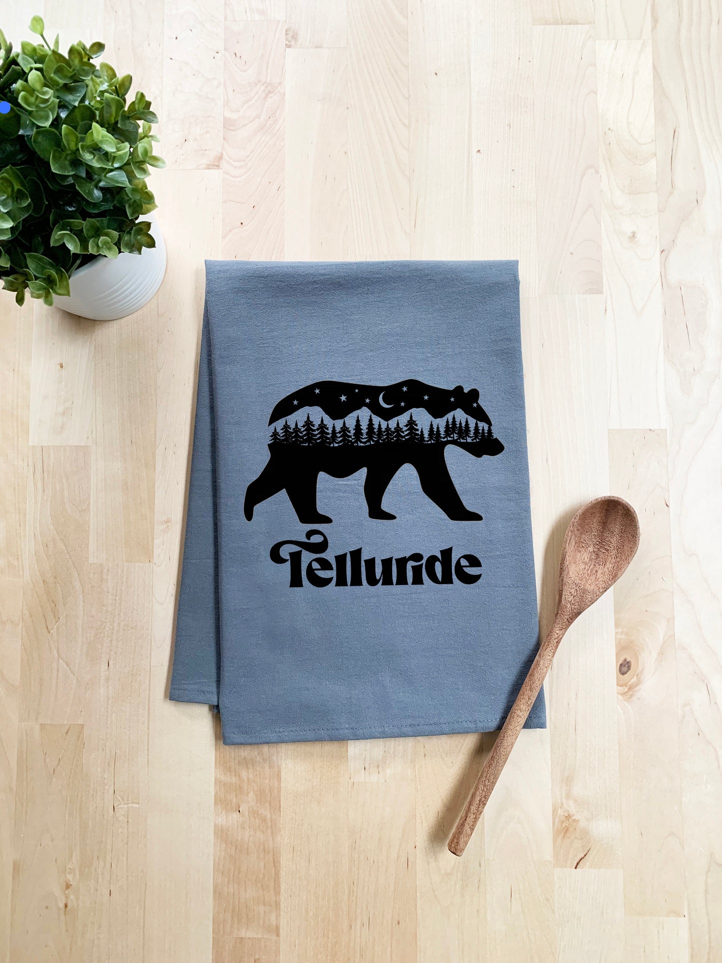 a tea towel with a bear on it and a spoon next to it