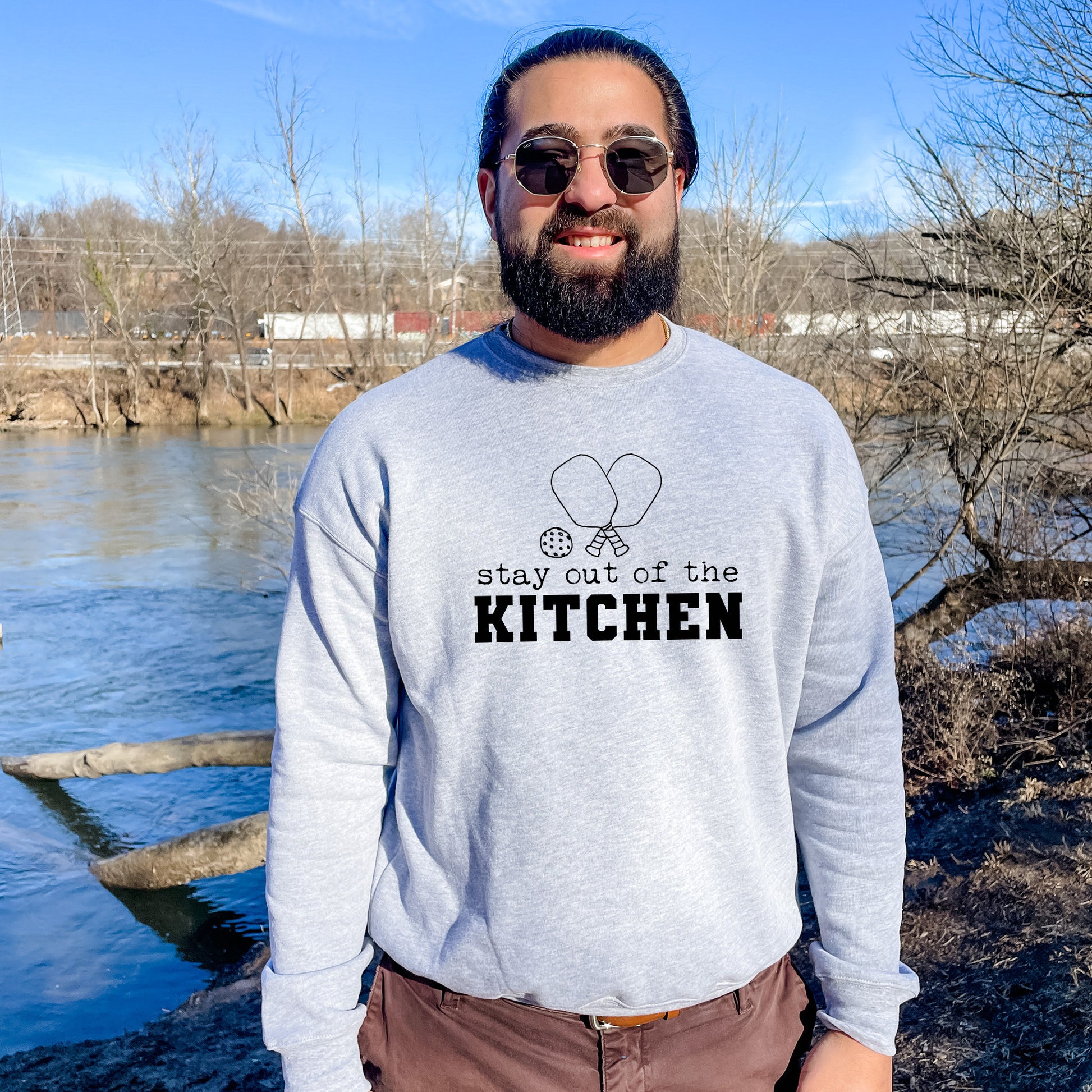 a man wearing a sweatshirt that says stay out of the kitchen