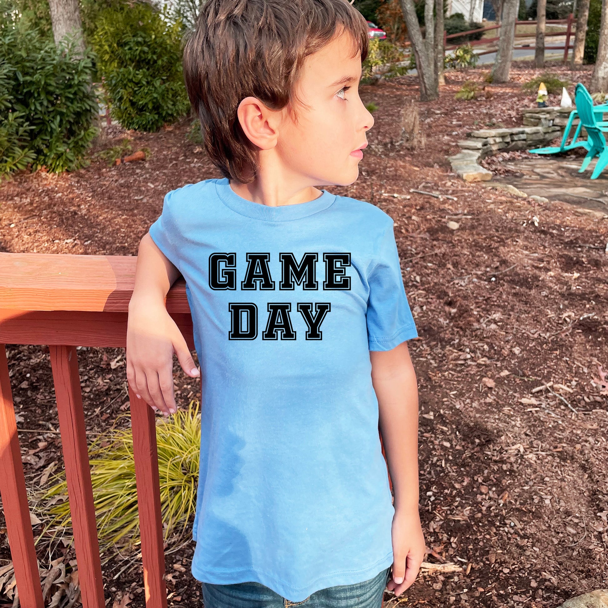 a young boy wearing a game day shirt