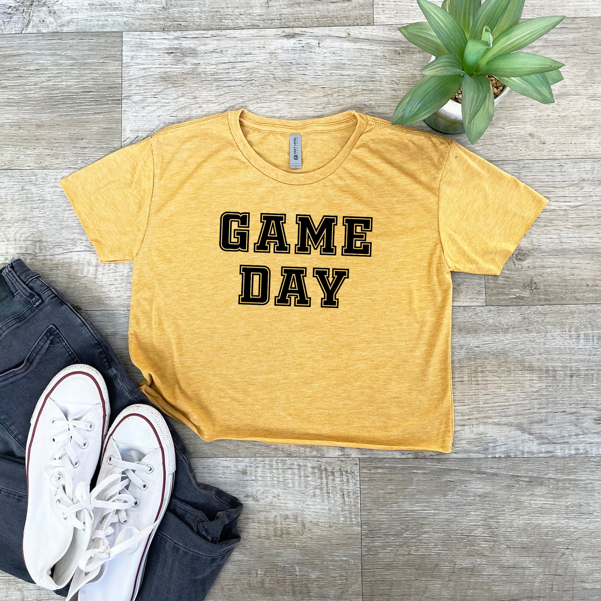 a t - shirt that says game day next to a pair of jeans