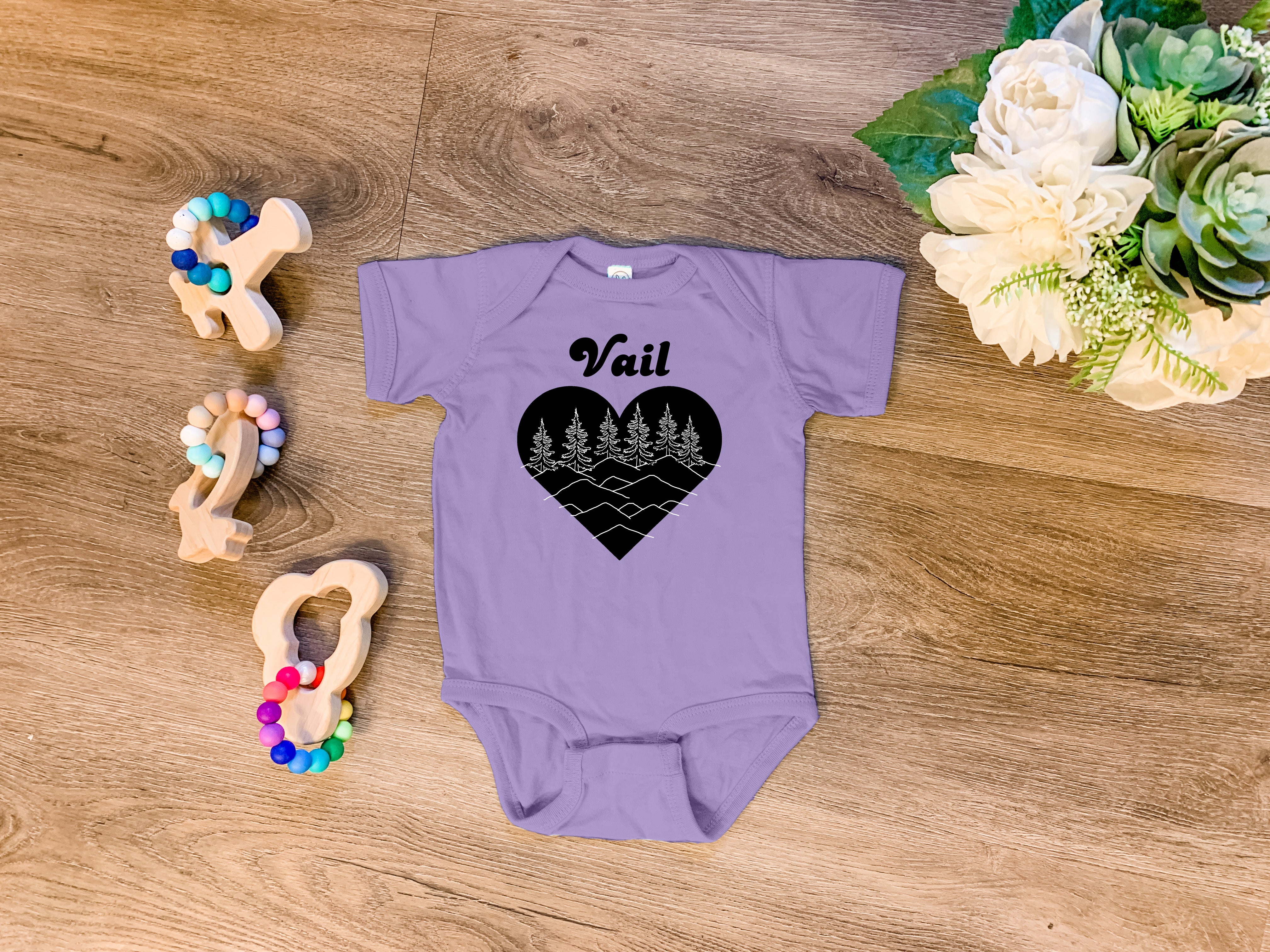 a purple onesuit with a black heart and trees on it