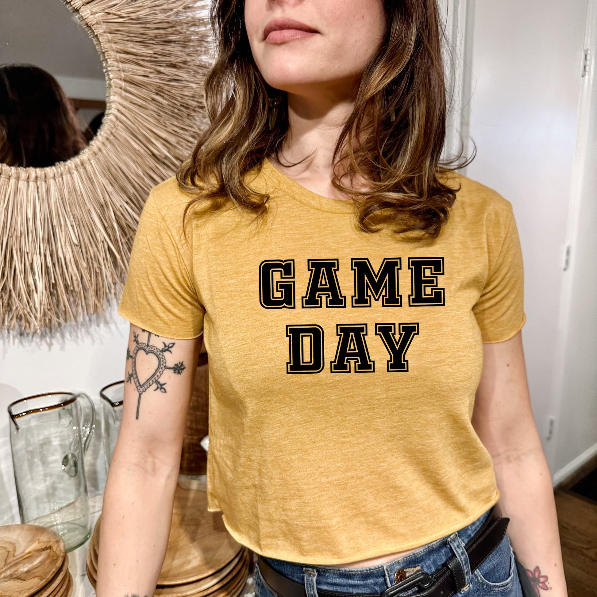 a woman standing in front of a mirror wearing a game day shirt
