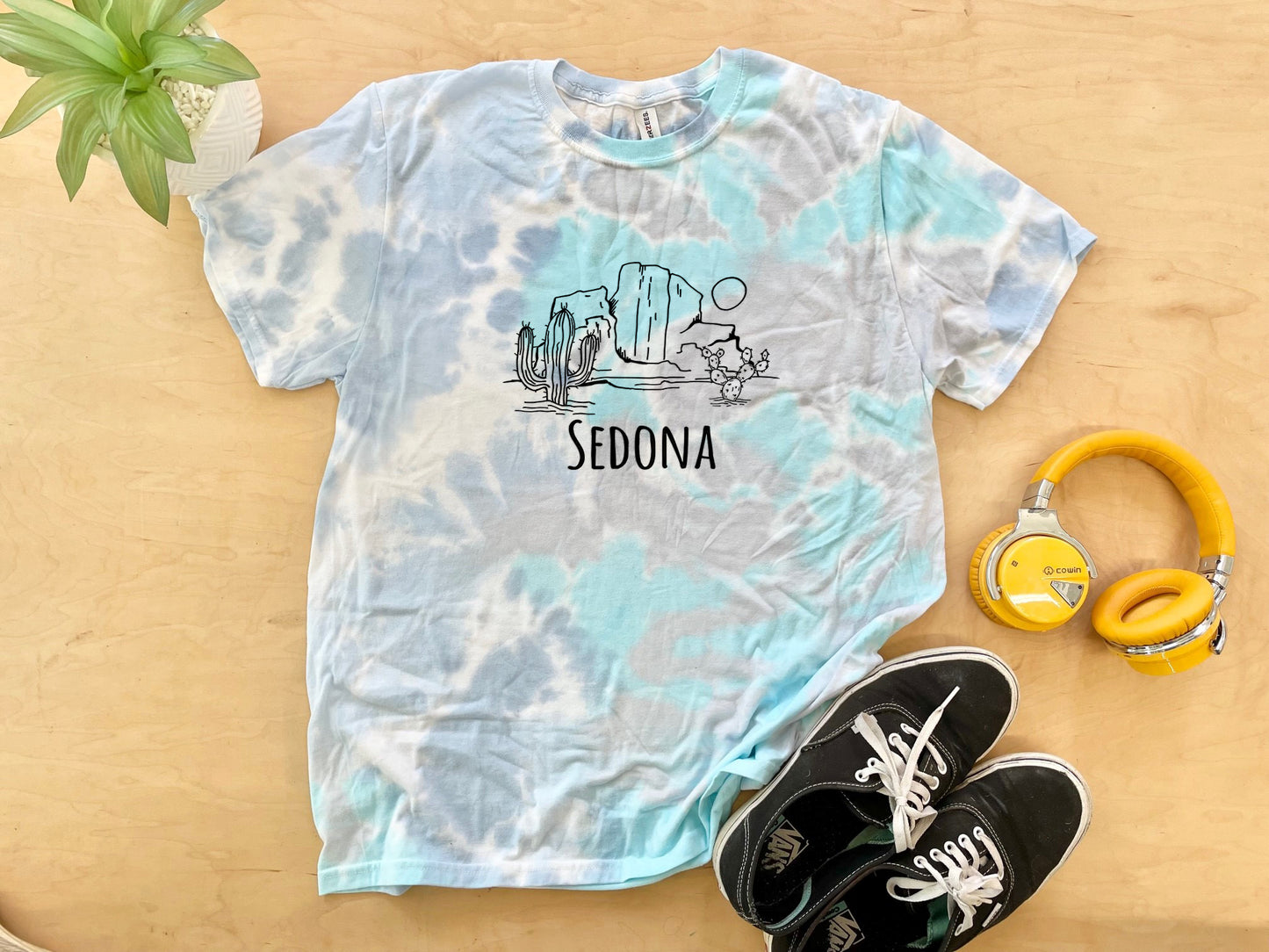 a tie dye shirt with the word sedona on it next to headphones