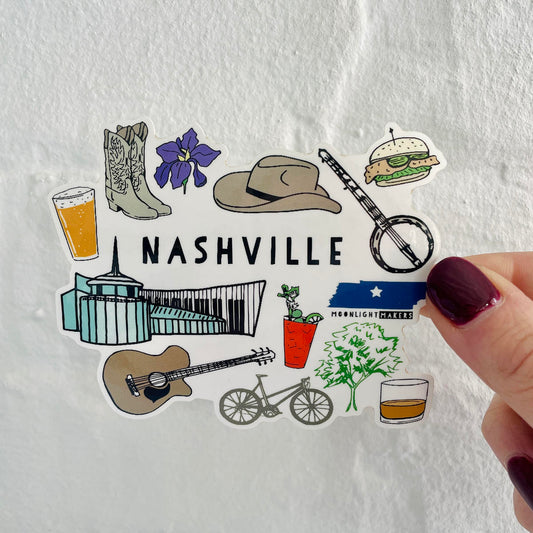 a hand holding a sticker with a picture of nashville
