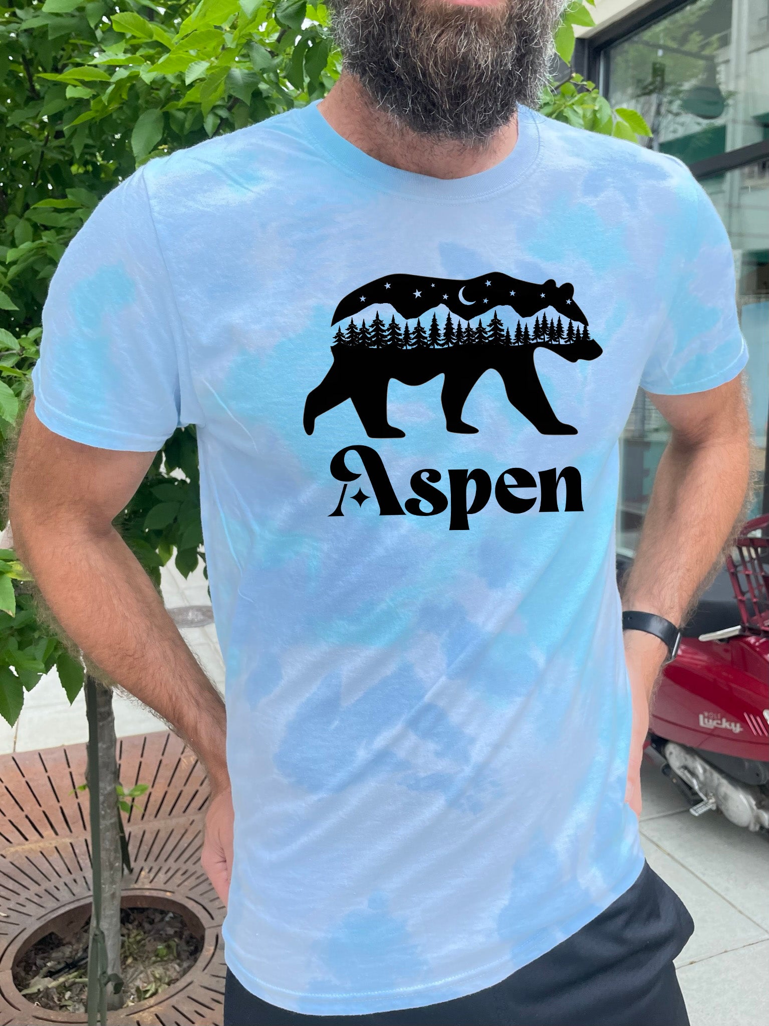 a man wearing a blue shirt with a bear on it