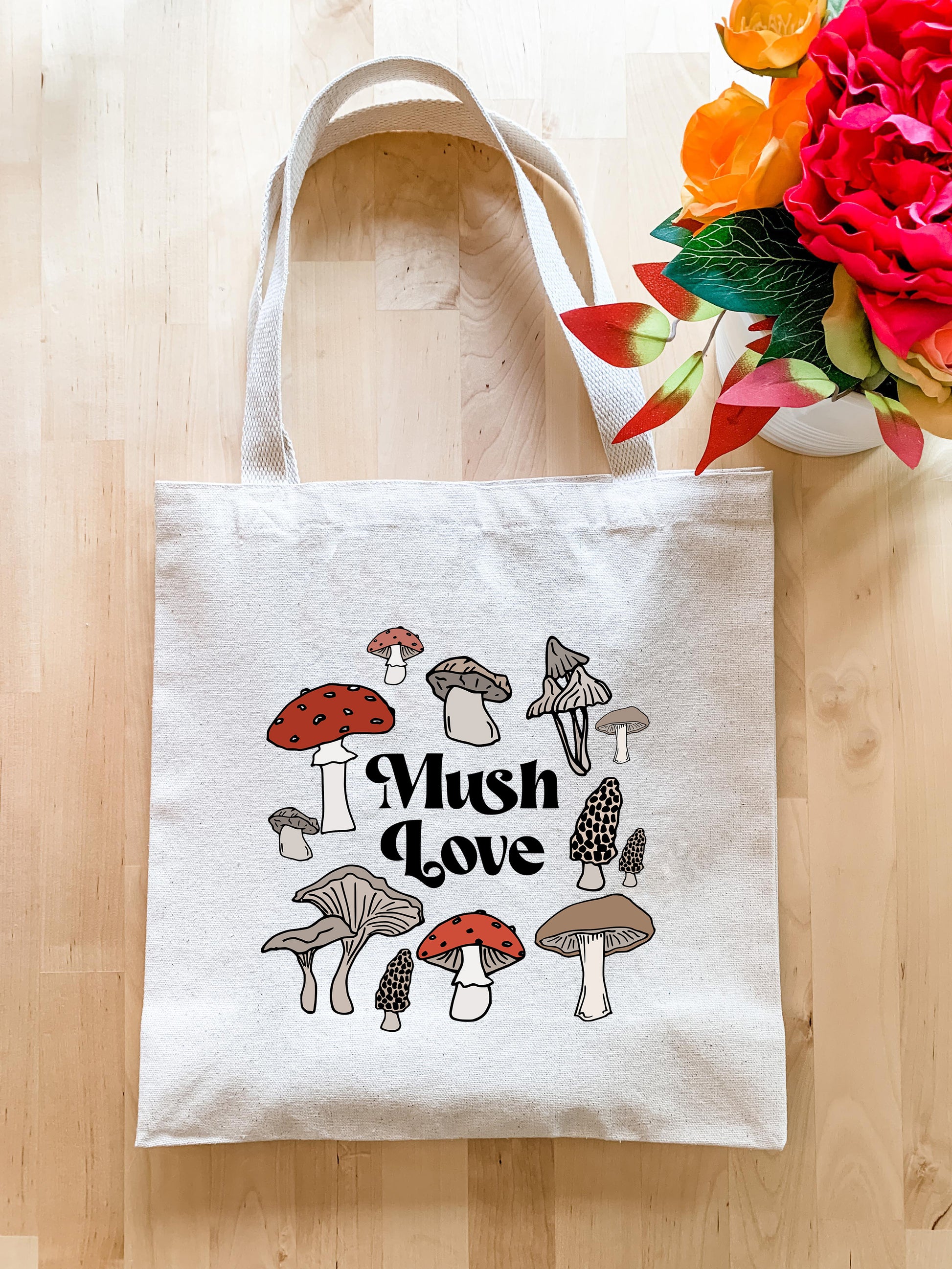 a mushroom love tote bag next to a bouquet of flowers