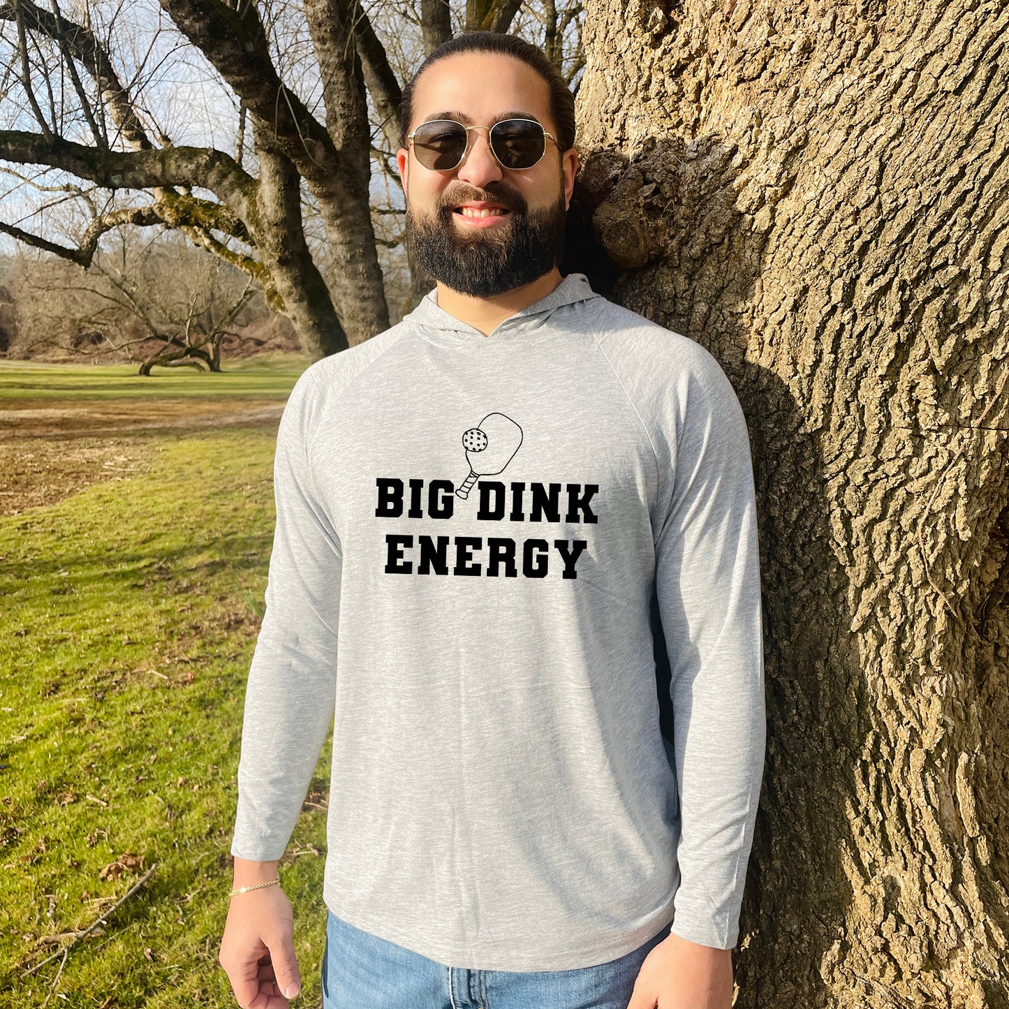a man standing next to a tree with the words big dink energy on it