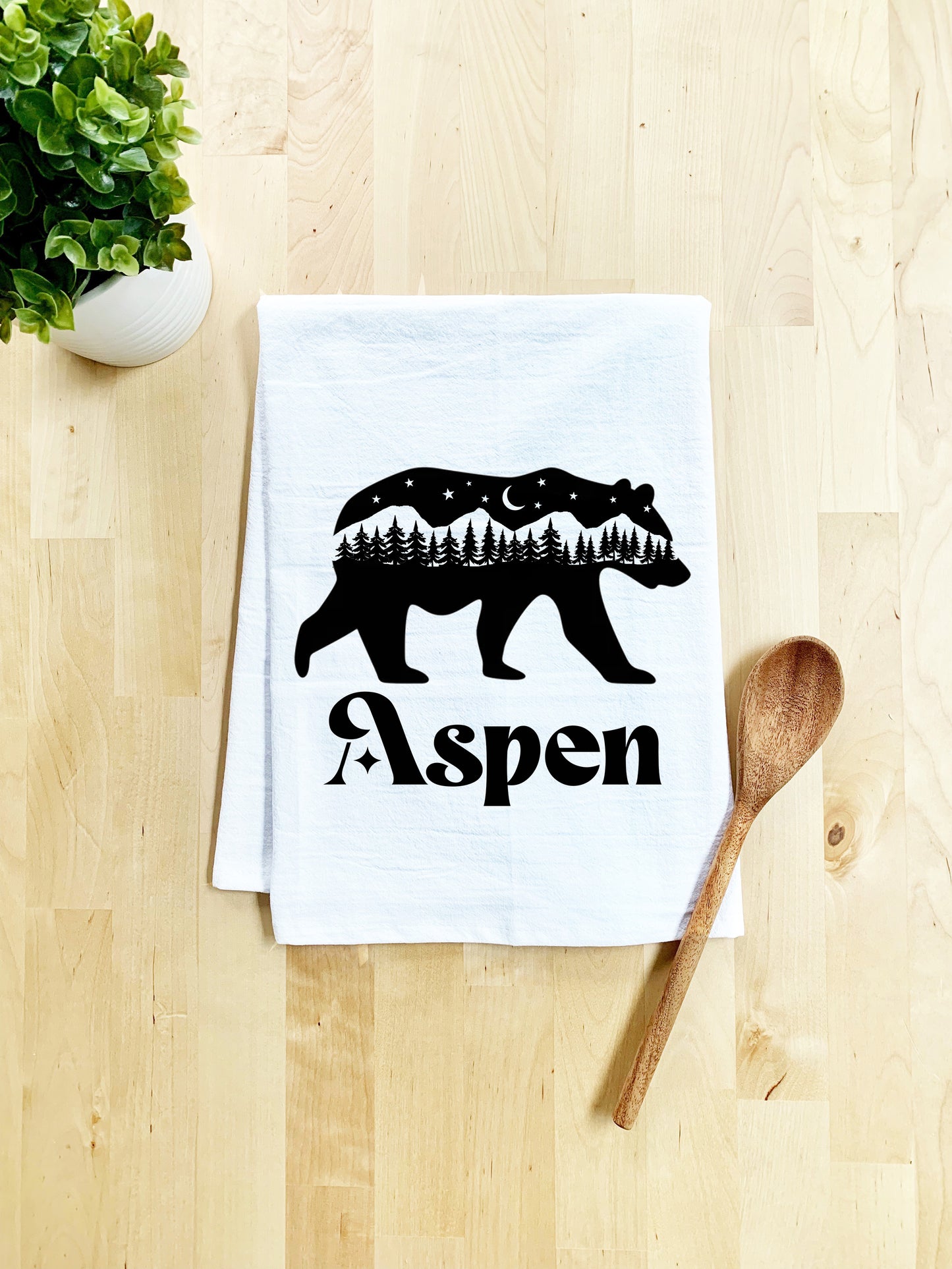 a tea towel with a bear on it next to a spoon