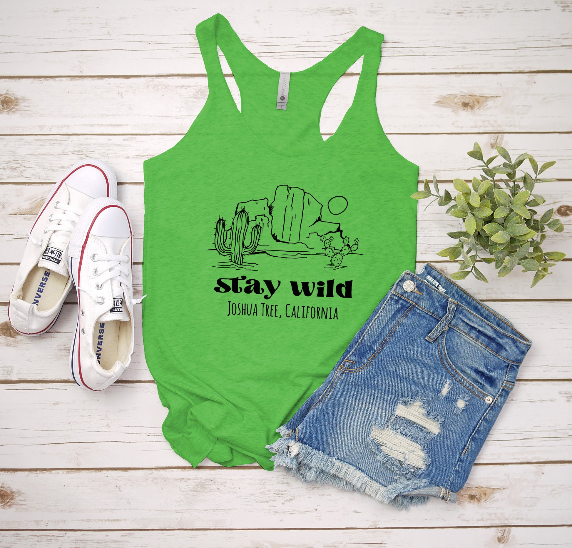 a green tank top that says stay wild and a pair of shorts
