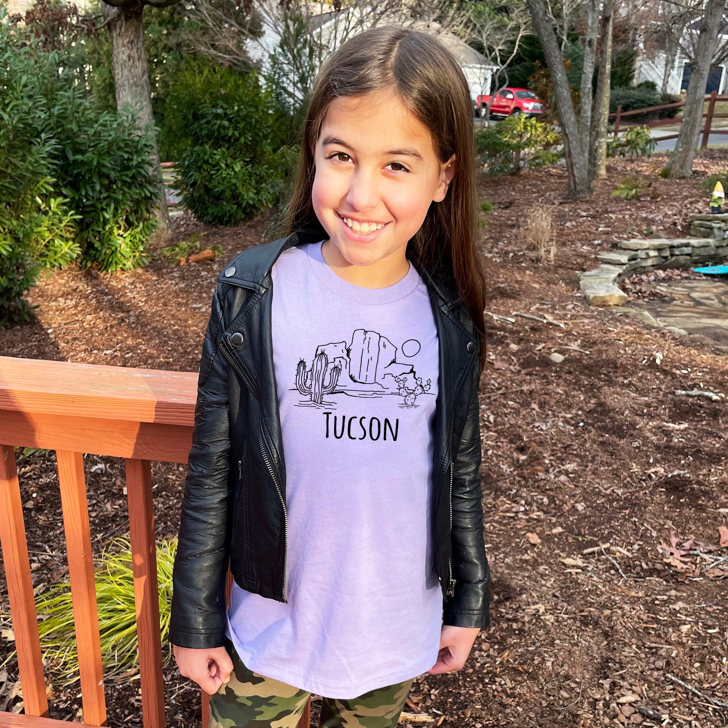 a young girl wearing a purple shirt and black jacket