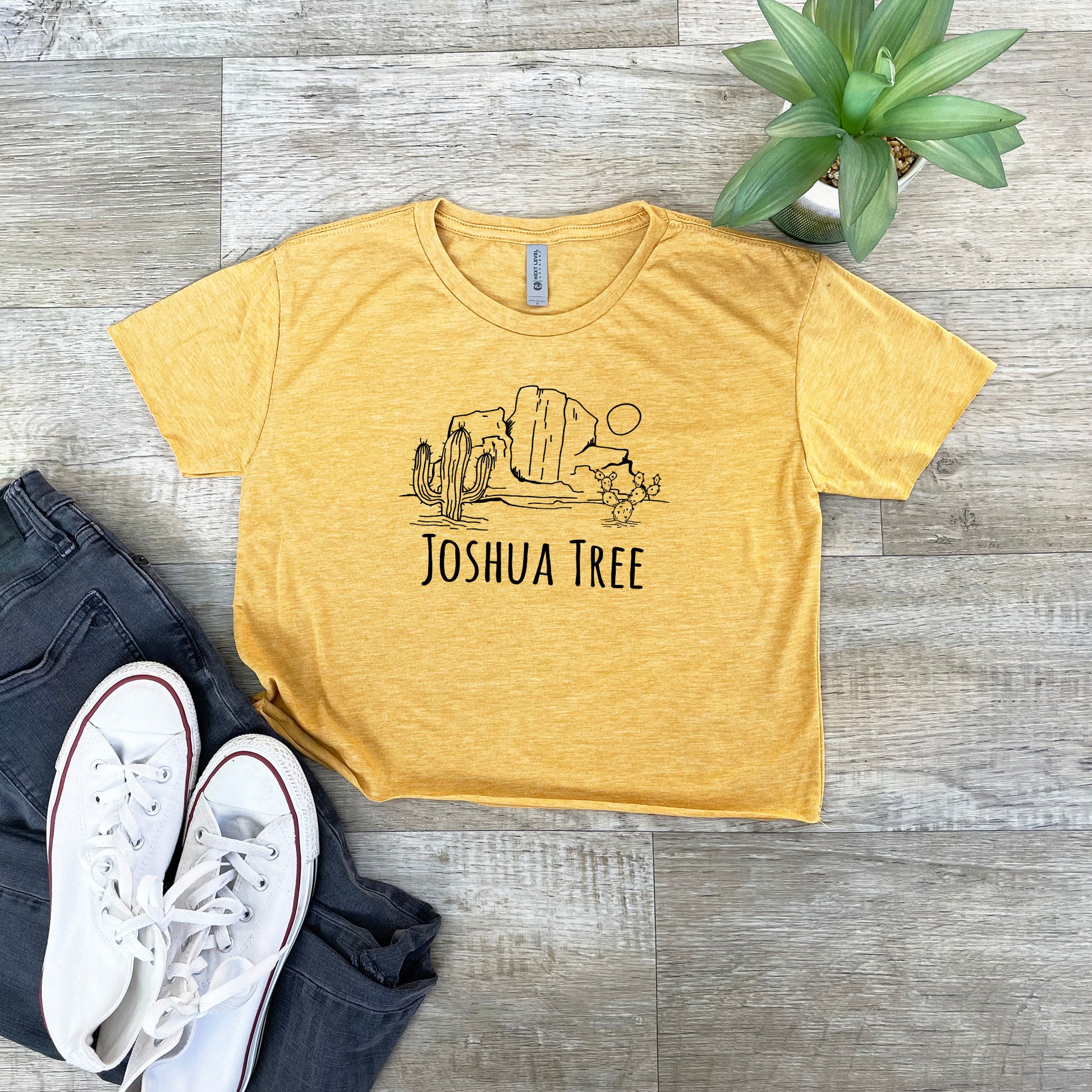 a yellow joshua tree t - shirt next to a pair of jeans
