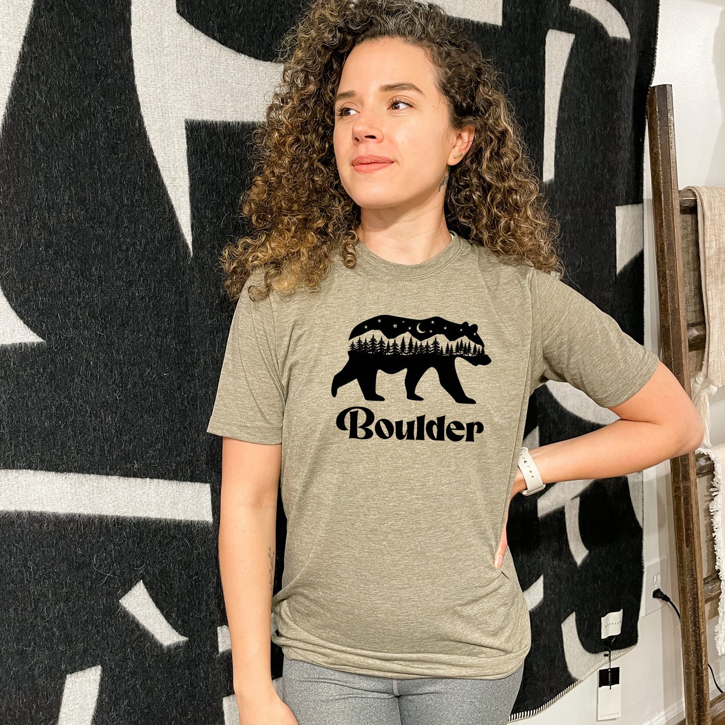 a woman standing in front of a wall with a bear t - shirt on