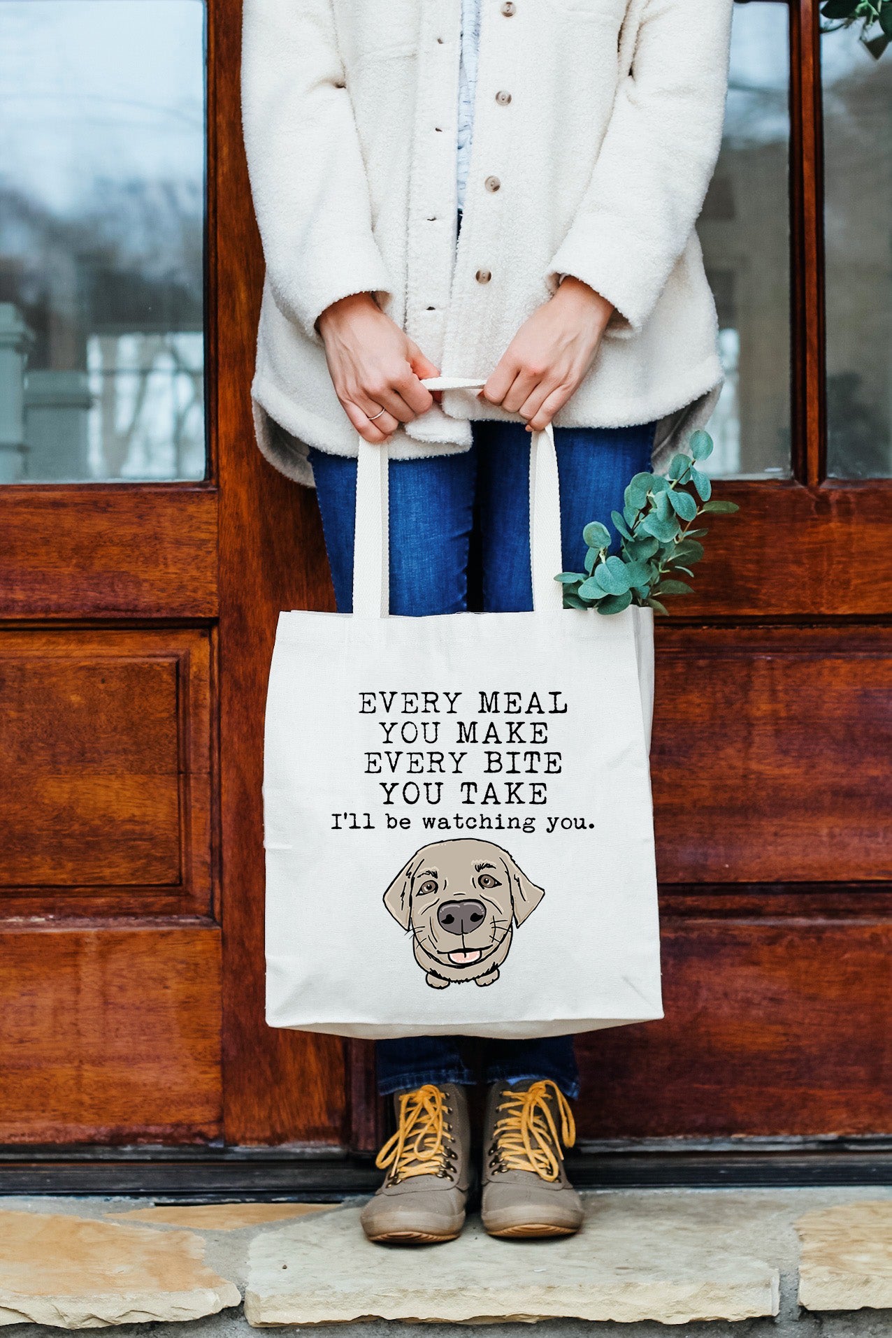 a woman holding a tote bag with a picture of a dog on it