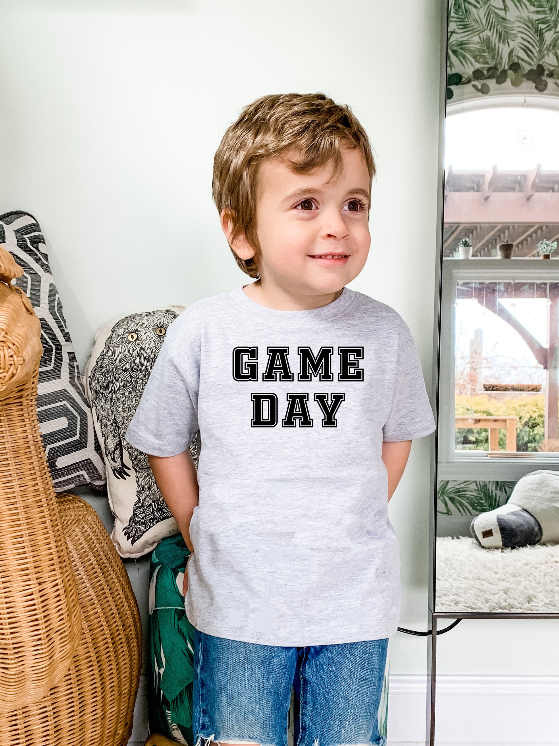 a young boy standing in front of a mirror