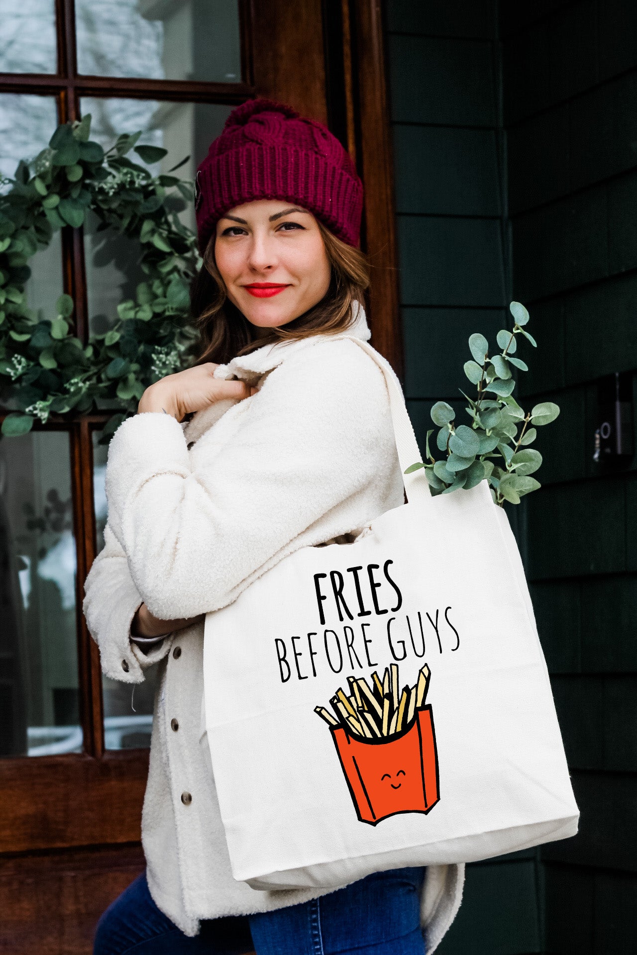 a woman carrying a bag that says fries before guys